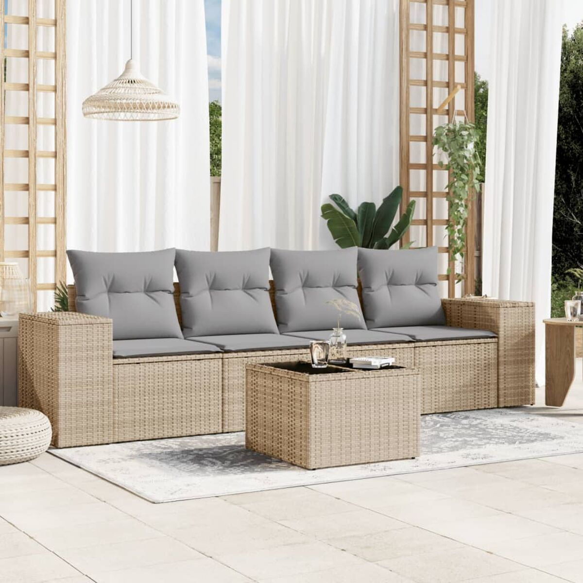 Rattan-Outdoor-Sofagarnitur mit grauen Kissen, Couchtisch und Teppich.