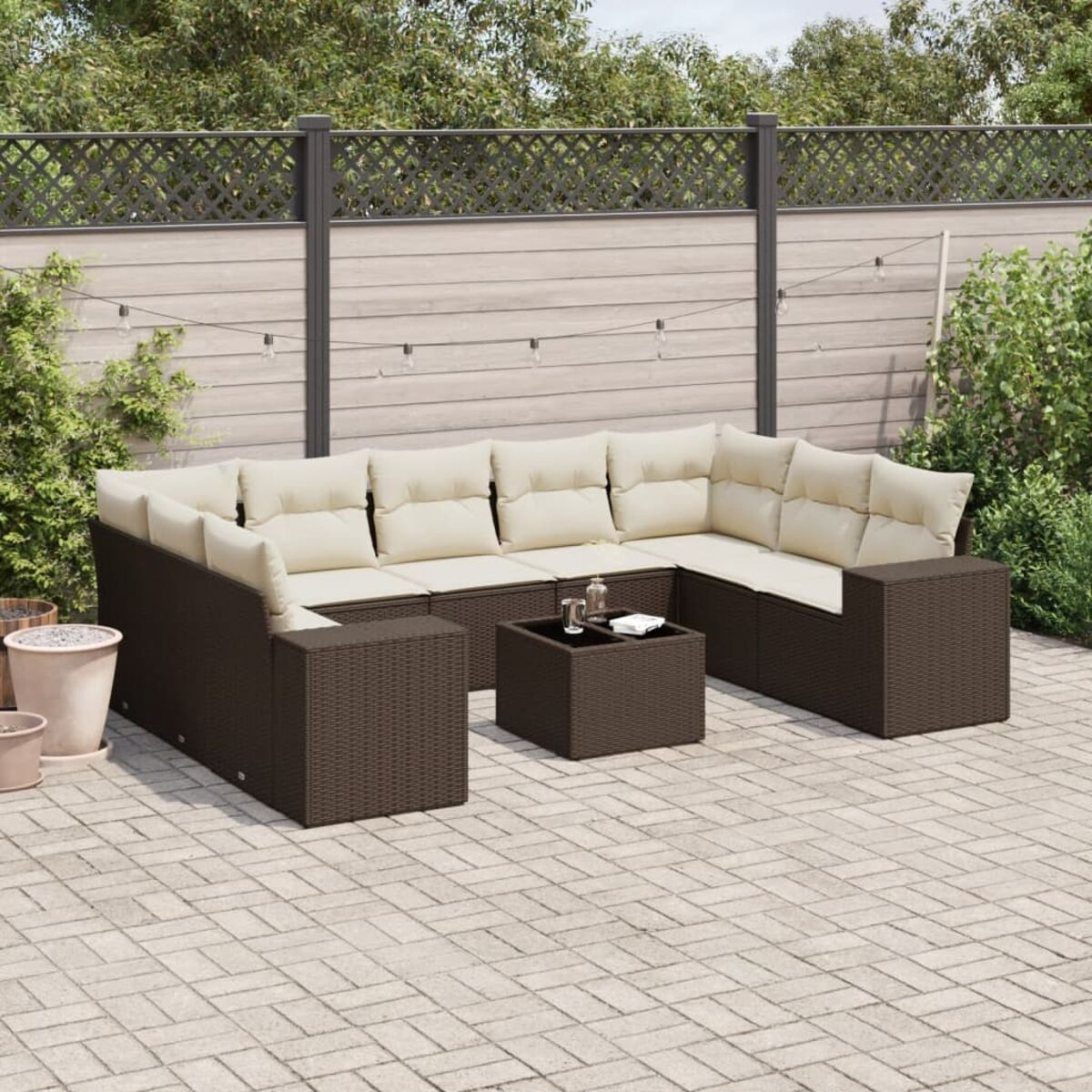 Divano componibile marrone da esterno con cuscini color crema. Include un divano componibile e un tavolino quadrato. Su un patio.