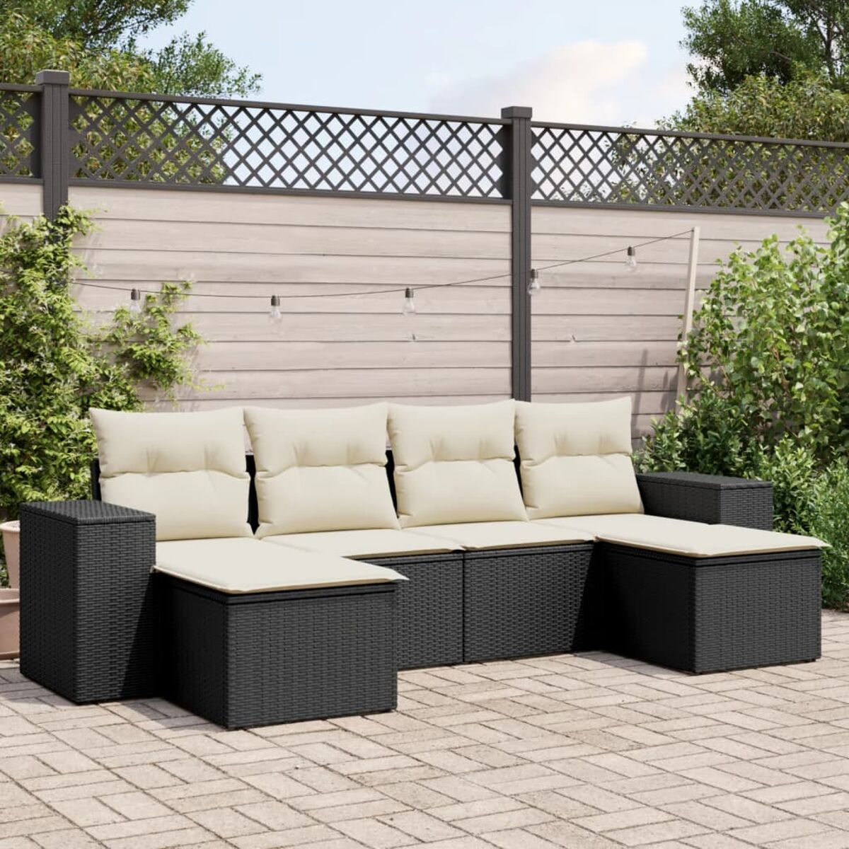 Schwarzes Rattan-Außensektional mit beigefarbenen Kissen. Ein Holzzaun und Pflanzen sind im Hintergrund.