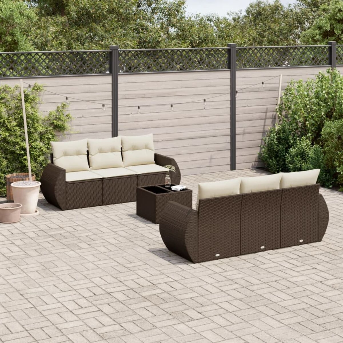 Un set da patio con due divani, un tavolino e un patio in mattoni. I divani sono marrone scuro.