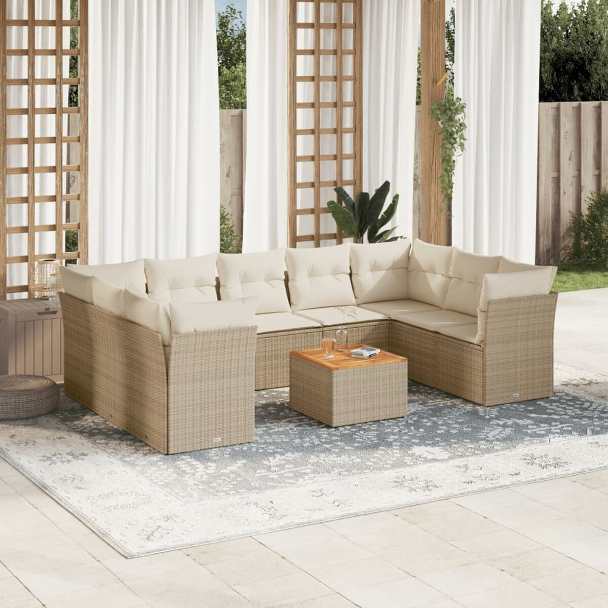 L-förmiges Rattansofa mit beigen Kissen, kleinem Tisch und hellem Teppich auf der Terrasse.