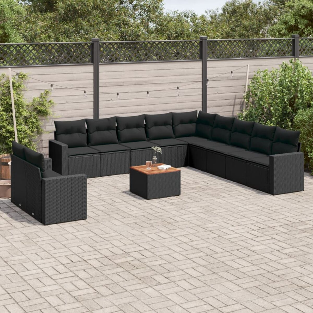 Outdoor-Rattan-Möbelset mit schwarzen Kissen. Enthält ein Sofa, einen Sessel und einen Couchtisch.