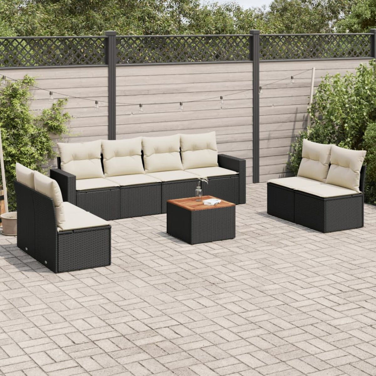 Schwarzes Korbsessel-Set mit beigen Kissen und Holztisch im Freien.