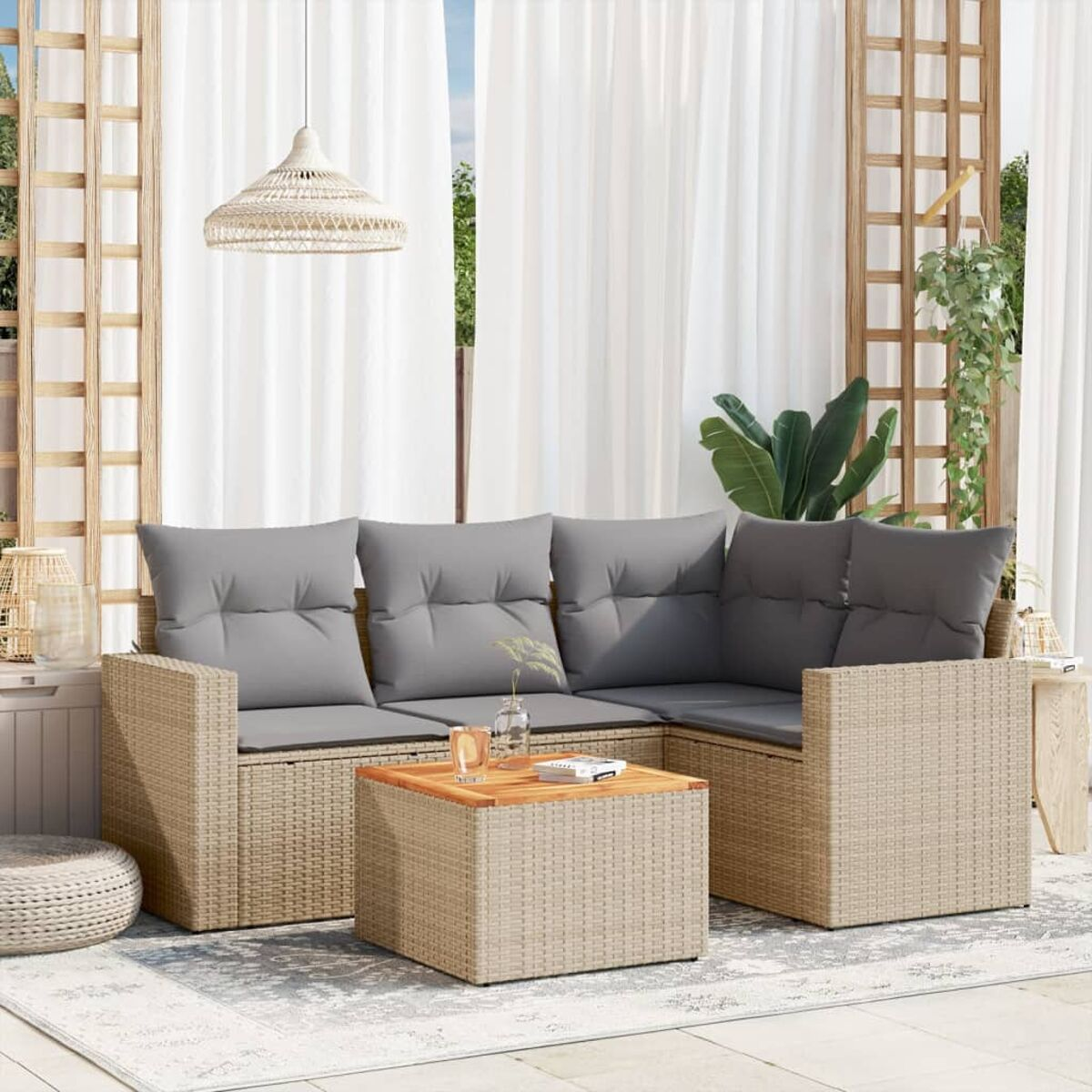 Ecksofa aus Weide für den Außenbereich mit grauen Kissen und Holztisch auf einer Terrasse.