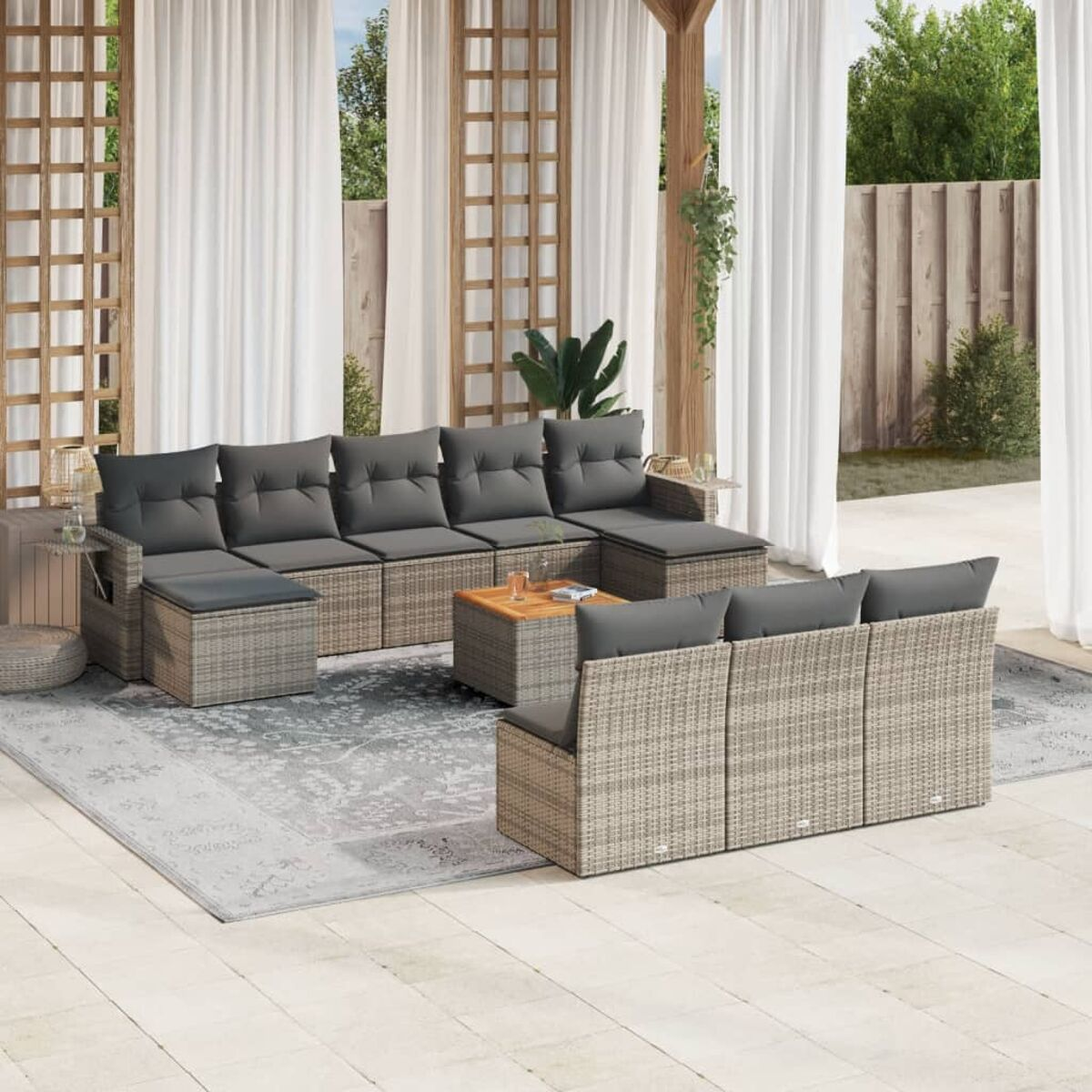 Ecksofa aus Korbgeflecht mit grauen Kissen und Couchtisch auf gemustertem Teppich, Vorhänge.