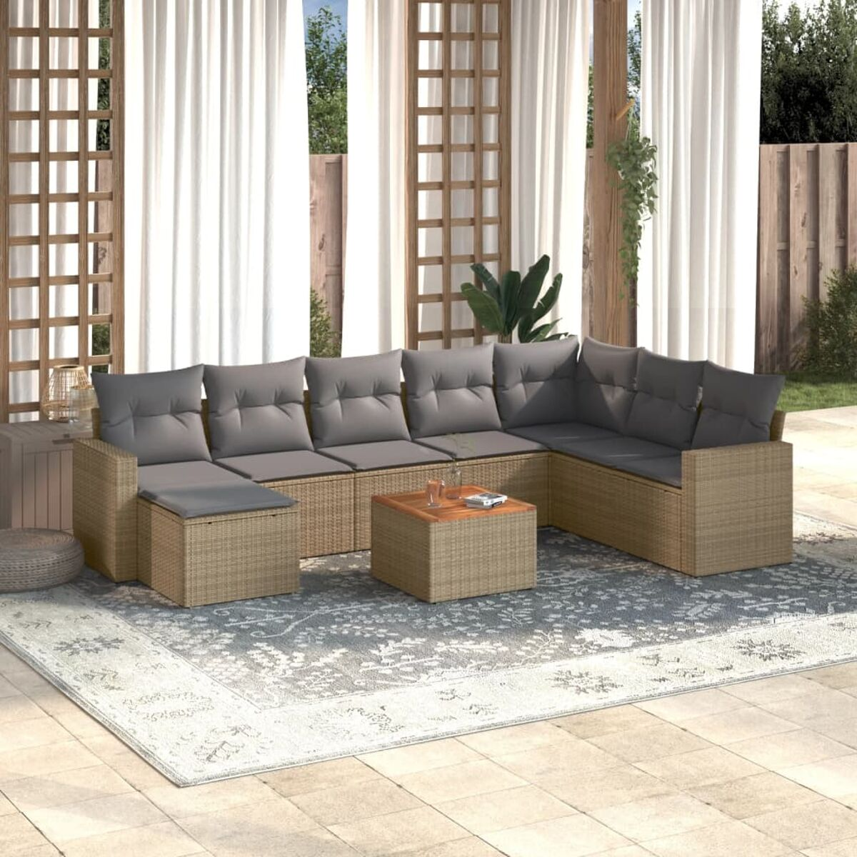 L-förmiges Terrassenmöbel-Set mit grauen Kissen auf Teppich, draußen.