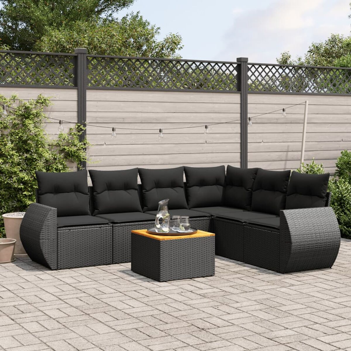 Schwarzes Outdoor-Ecksofa mit Beistelltisch, auf einer Terrasse.
