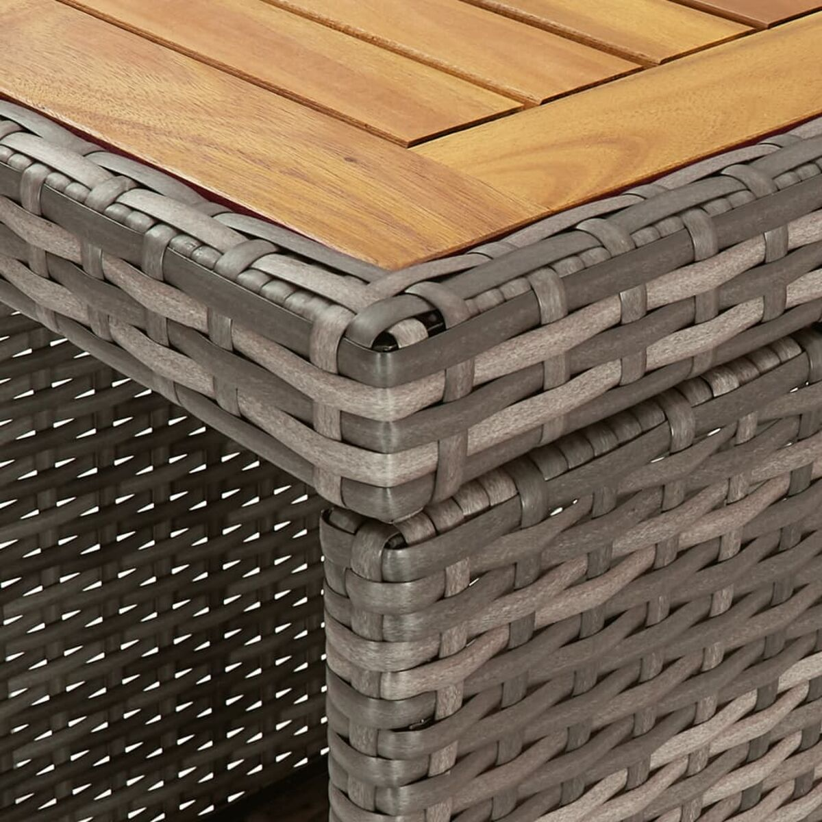 Primo piano di un angolo di tavolo in legno con dettagli di tessitura in vimini grigio.