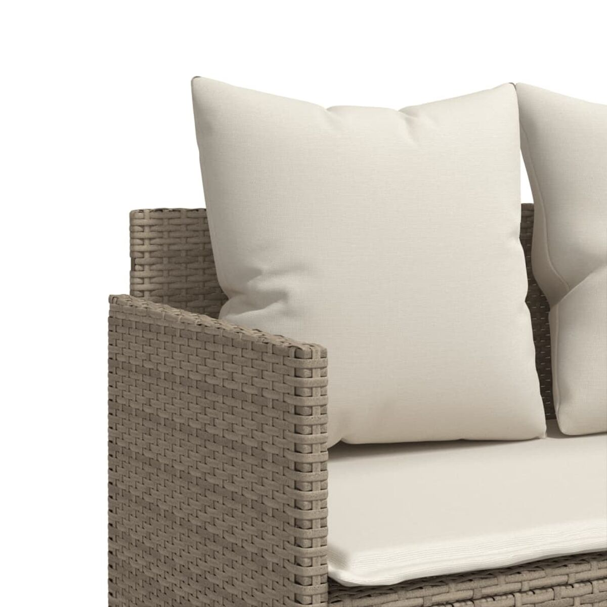 Nahaufnahme eines Rattansofas mit cremefarbenen Kissen. Die gewebte Textur des Sofas ist sichtbar.