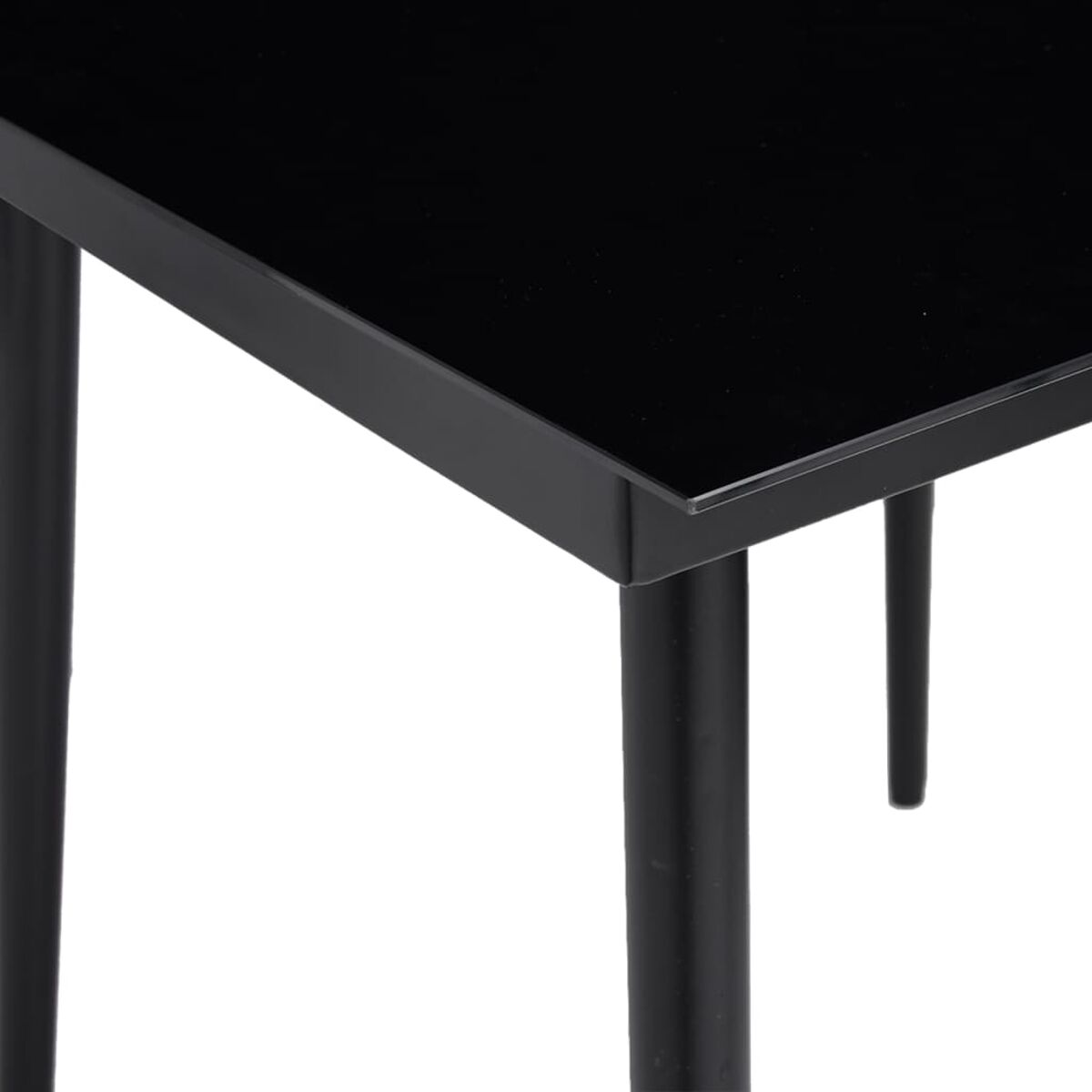 Schwarzer Tisch mit schwarzen Beinen. Der Tisch hat eine glänzende, schwarze Oberfläche, die das Licht reflektiert.