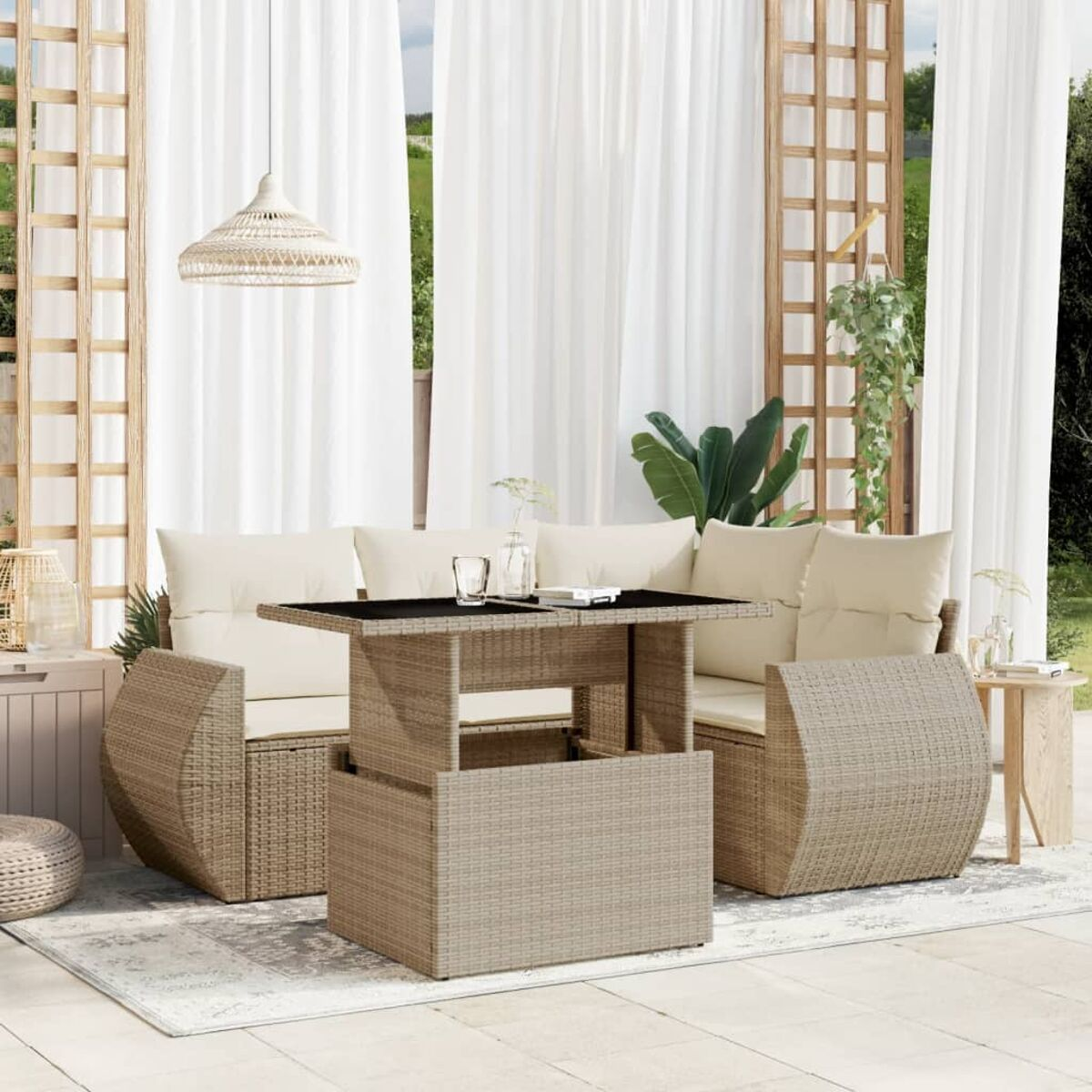 Divano componibile in rattan beige con cuscini color crema e un tavolo nero, su un tappeto grigio.