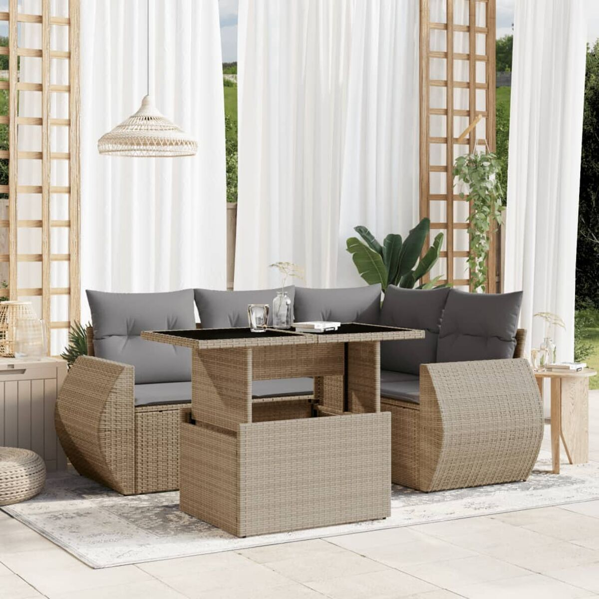 Outdoor-Wicker-Sofa mit einem Tisch auf einem Teppich, in der Nähe von Vorhängen und Pflanzen.
