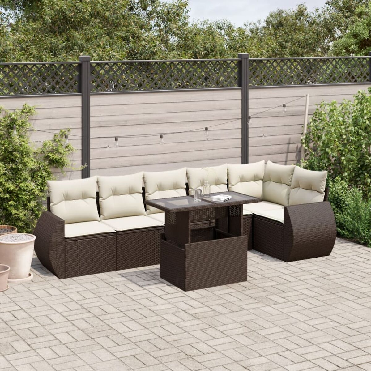 Braunes Outdoor-Sofa-Set mit cremefarbenen Kissen und einem schwarzen Tisch.
