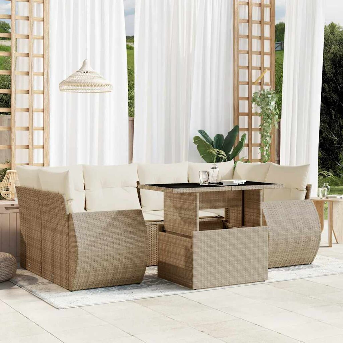 Set divani in vimini con cuscini beige, tavolo con piano in vetro e tende bianche.