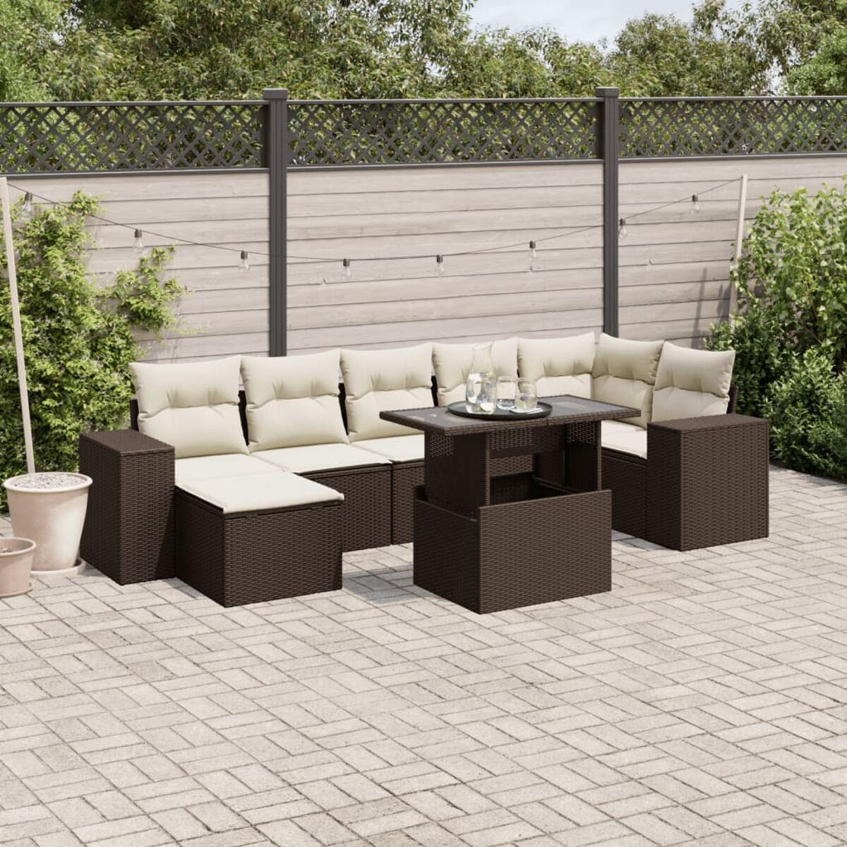 Set di mobili da esterno: divano, sedie e tavolo, su un patio in mattoni, sfondo naturale.
