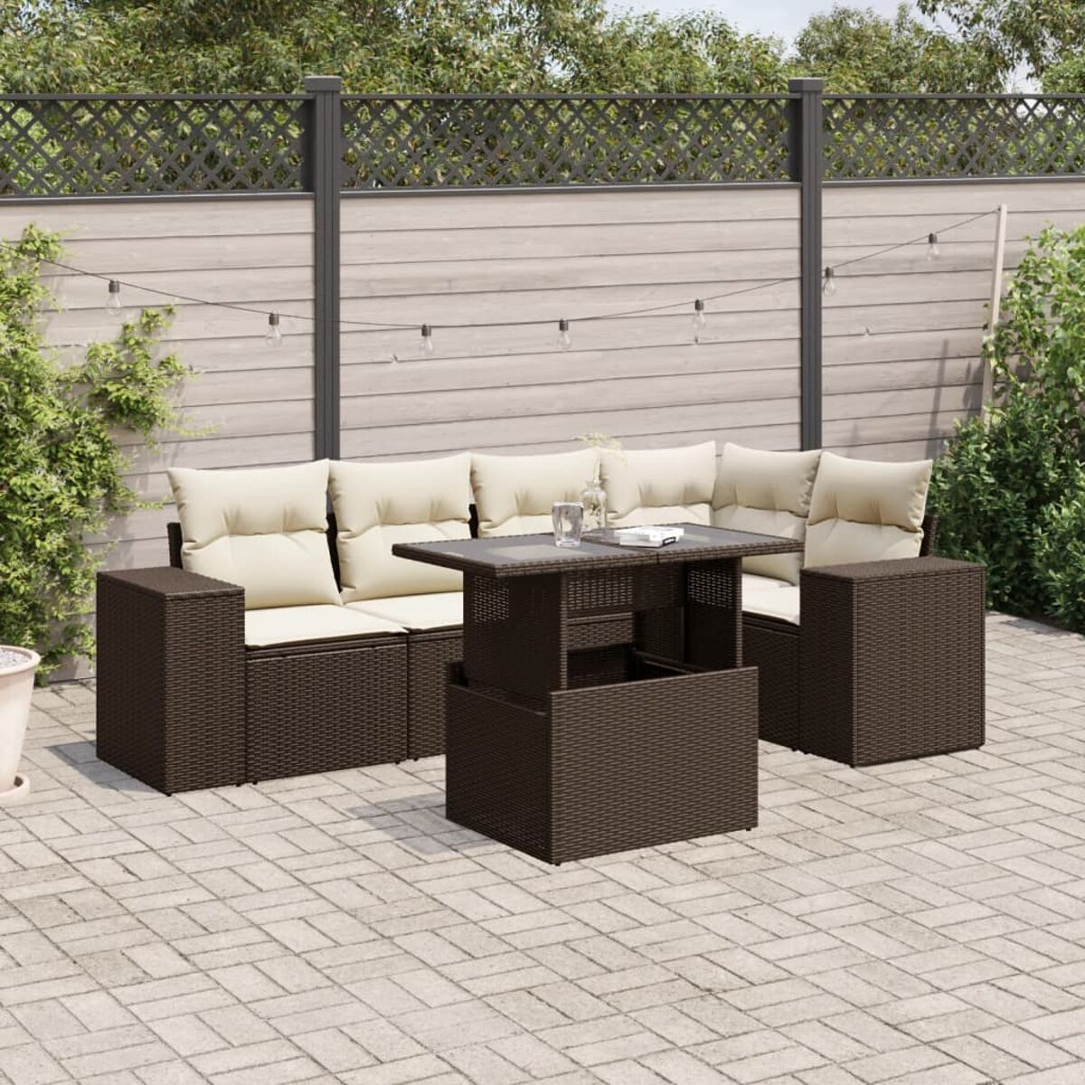 Sitzbereich im Freien mit braunen Korbmöbeln, beigen Kissen und einem Tisch. Ziegel-Patio in der Szene.
