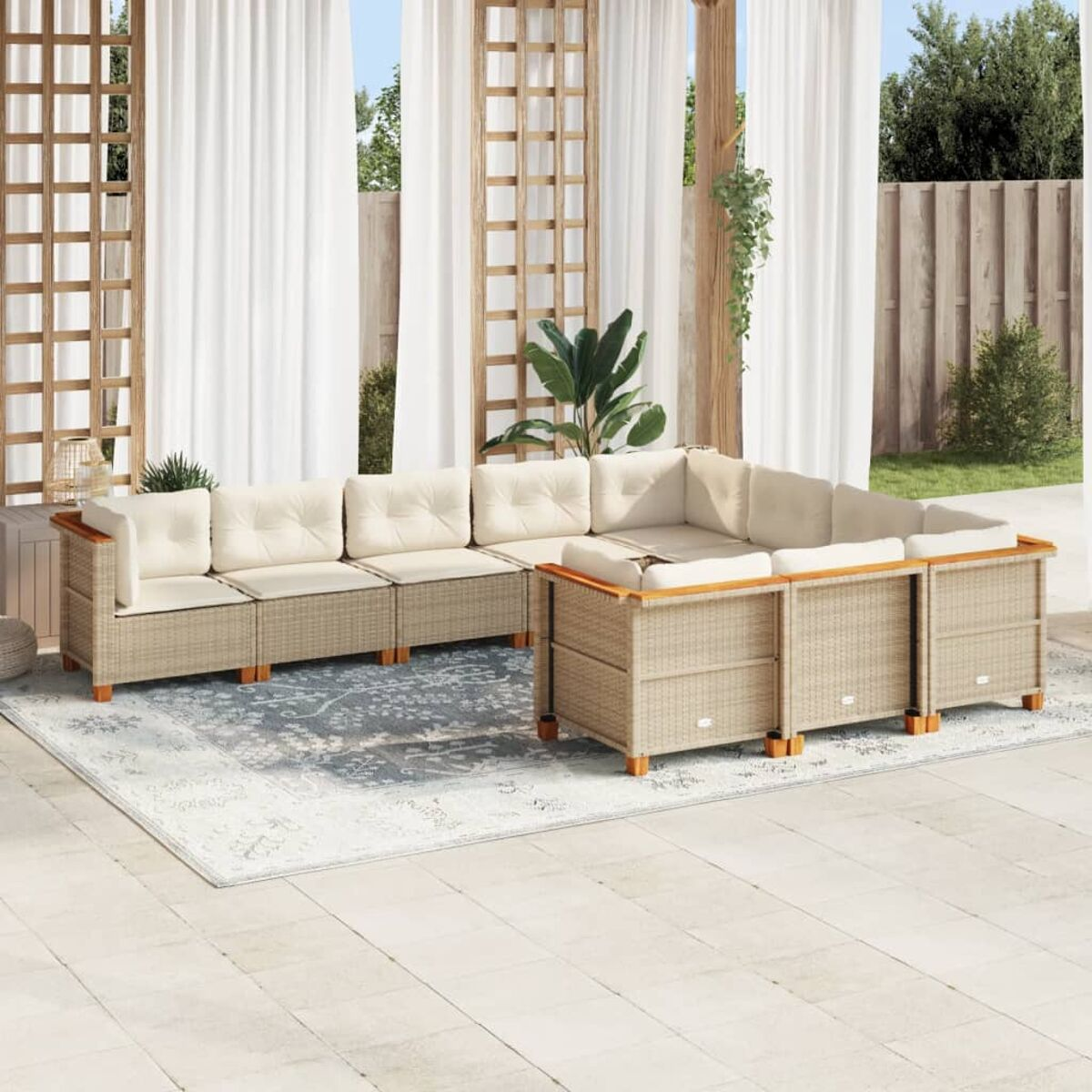 Divano angolare da esterno in vimini beige con cuscini color crema. Lo sfondo include un tappeto e tende.