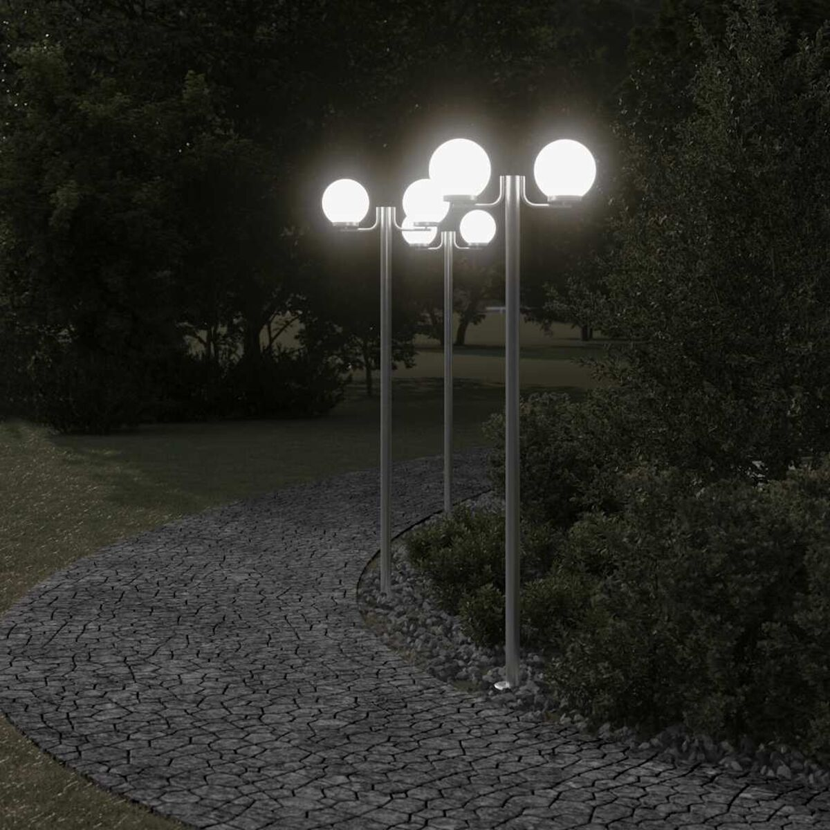 Un sentiero di pietra che serpeggia in un'area erbosa di notte, illuminato dai lampioni.
