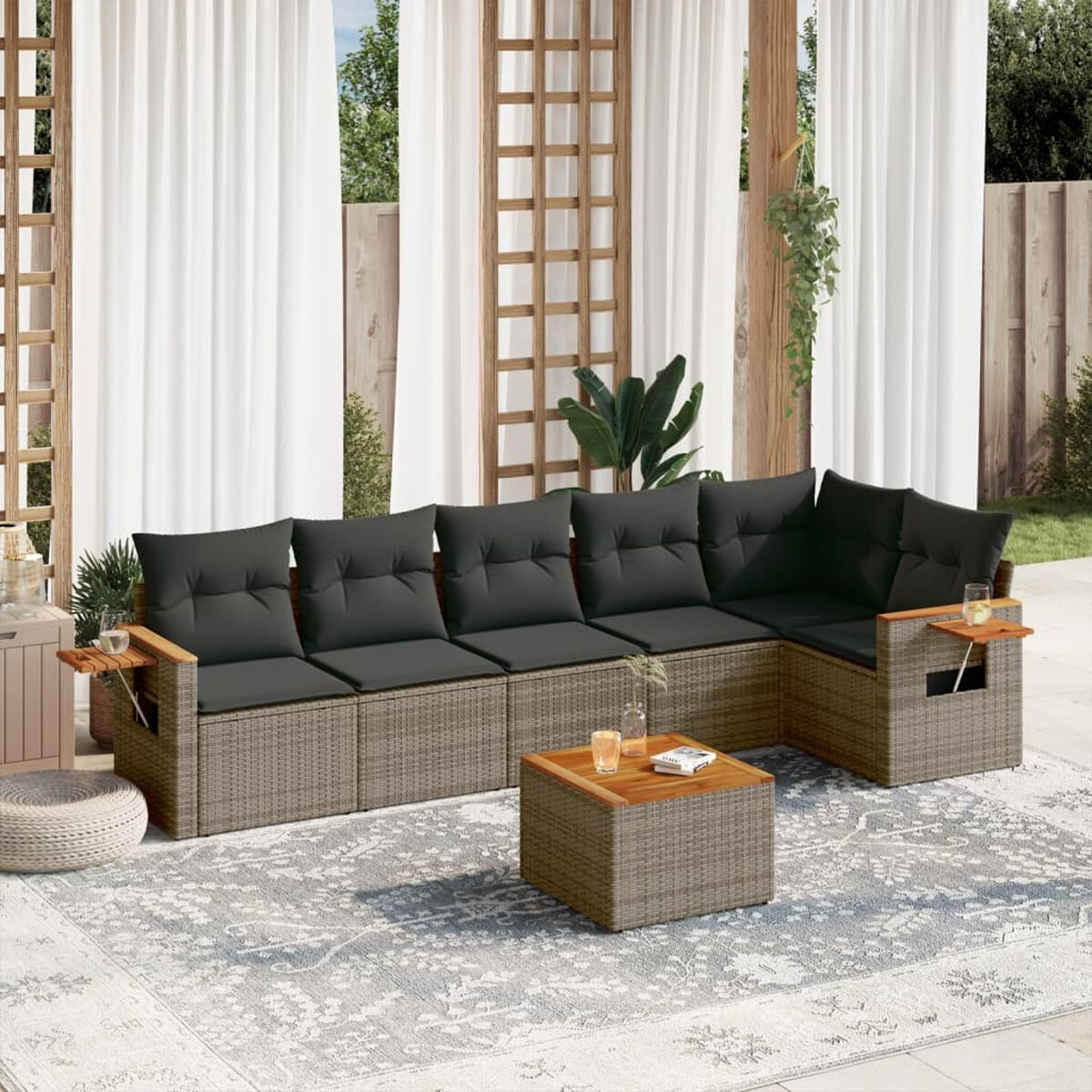 Rattansofa mit grauen Kissen und einem hölzernen Beistelltisch, mit Teppich und Couchtisch.