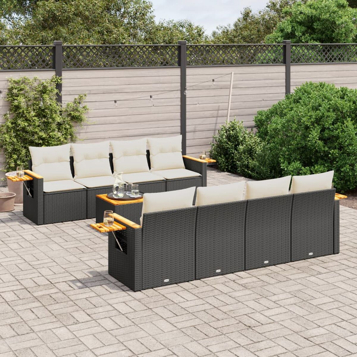 Ein Outdoor-Terrassenset mit schwarzen Korbmöbeln, beigen Kissen und Holztischen. Die Kulisse ist eine Terrasse.