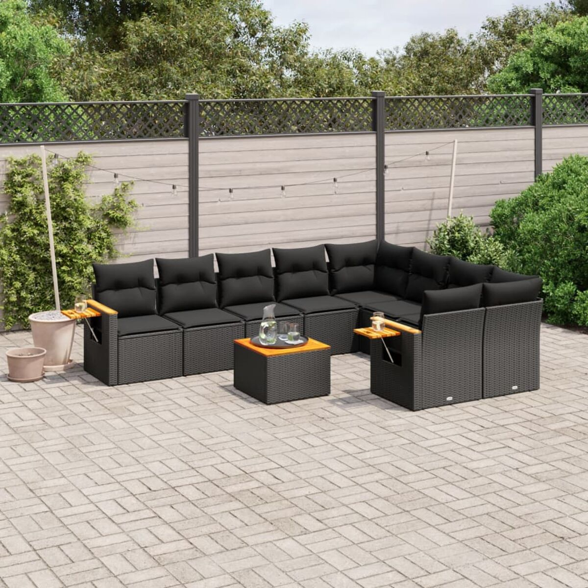 Schwarzes Outdoor-Ecksofa aus Korbgeflecht mit schwarzen Kissen und einem Tisch auf einer Terrasse.