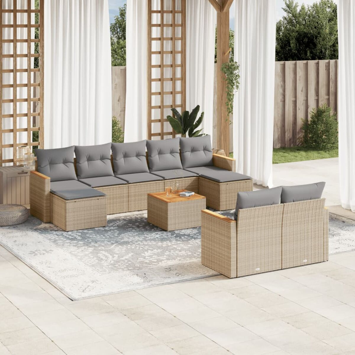 Terrassenset im Freien mit hellen Korbmöbeln, grauen Kissen und einem Holztisch.