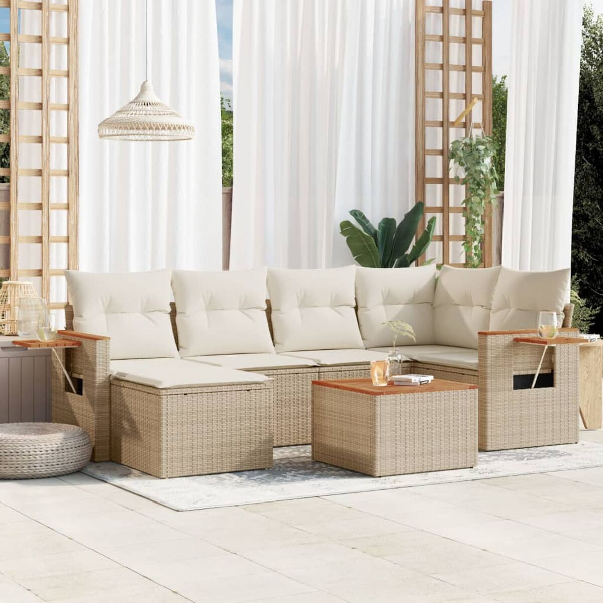 Outdoor-Geflecht-Schnitt mit cremefarbenen Kissen und einem Tisch mit Getränken und Gläsern.