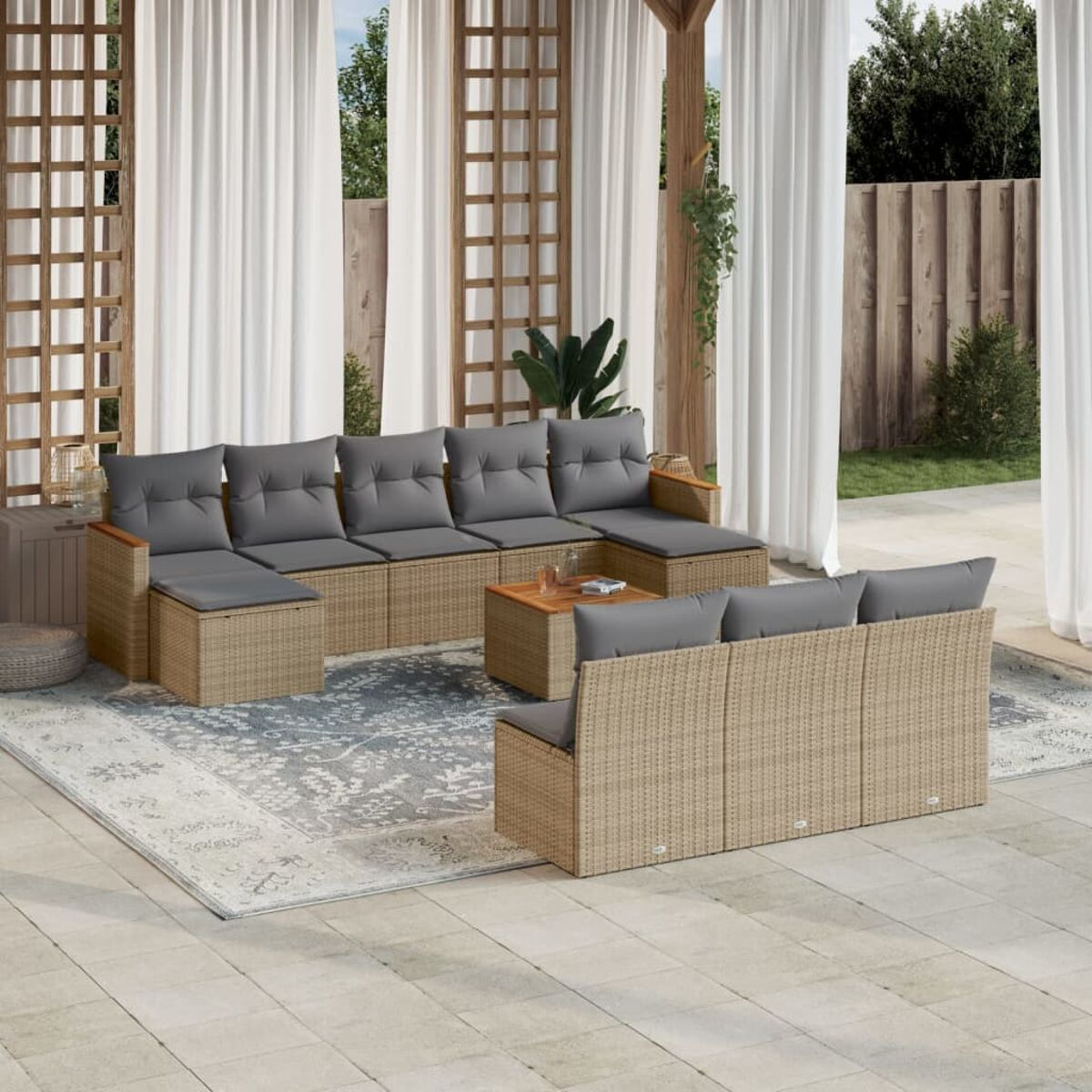 Outdoor-Rattan-Möbel auf einer Terrasse mit Teppich. Enthält Sofa, Tisch und Beistelltische.