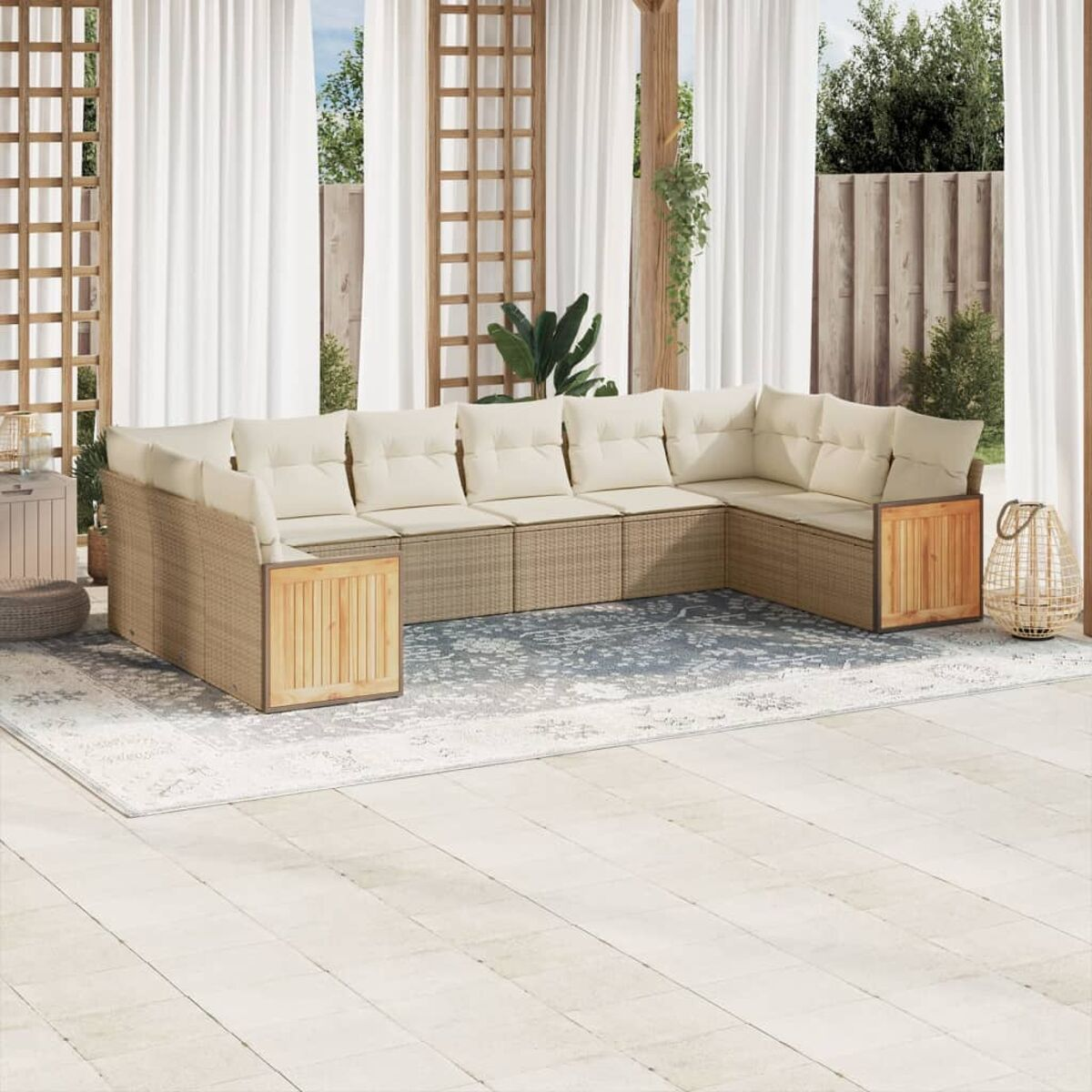 Beiges Outdoor-Sofa-Set aus Korbgeflecht mit weißen Kissen und einem Holztisch. Weiße Vorhänge und ein Teppich sind sichtbar.