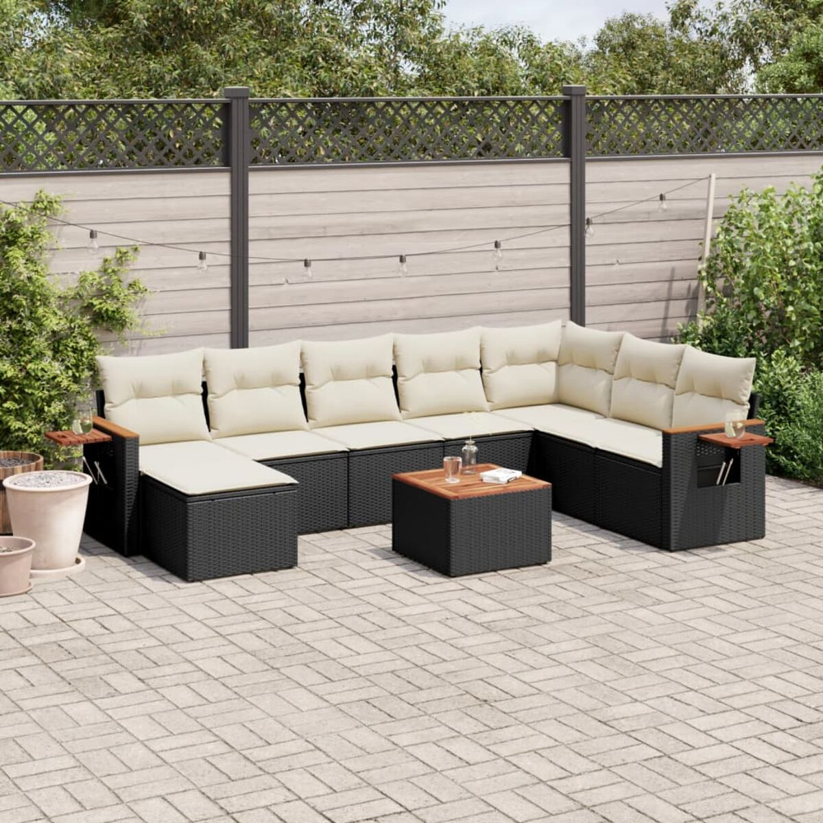 Schwarzes Ecksofa aus Korbgeflecht mit cremefarbenen Kissen, Tisch und Holzarmlehnen.