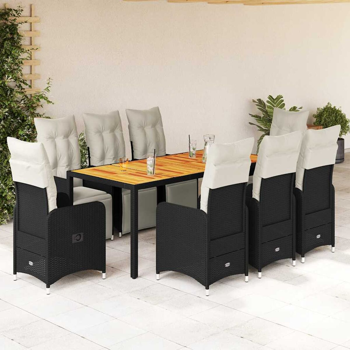 Set da pranzo nero da esterno con cuscini bianchi, tavolo in legno e bevande. Il tavolo è apparecchiato con bicchieri.