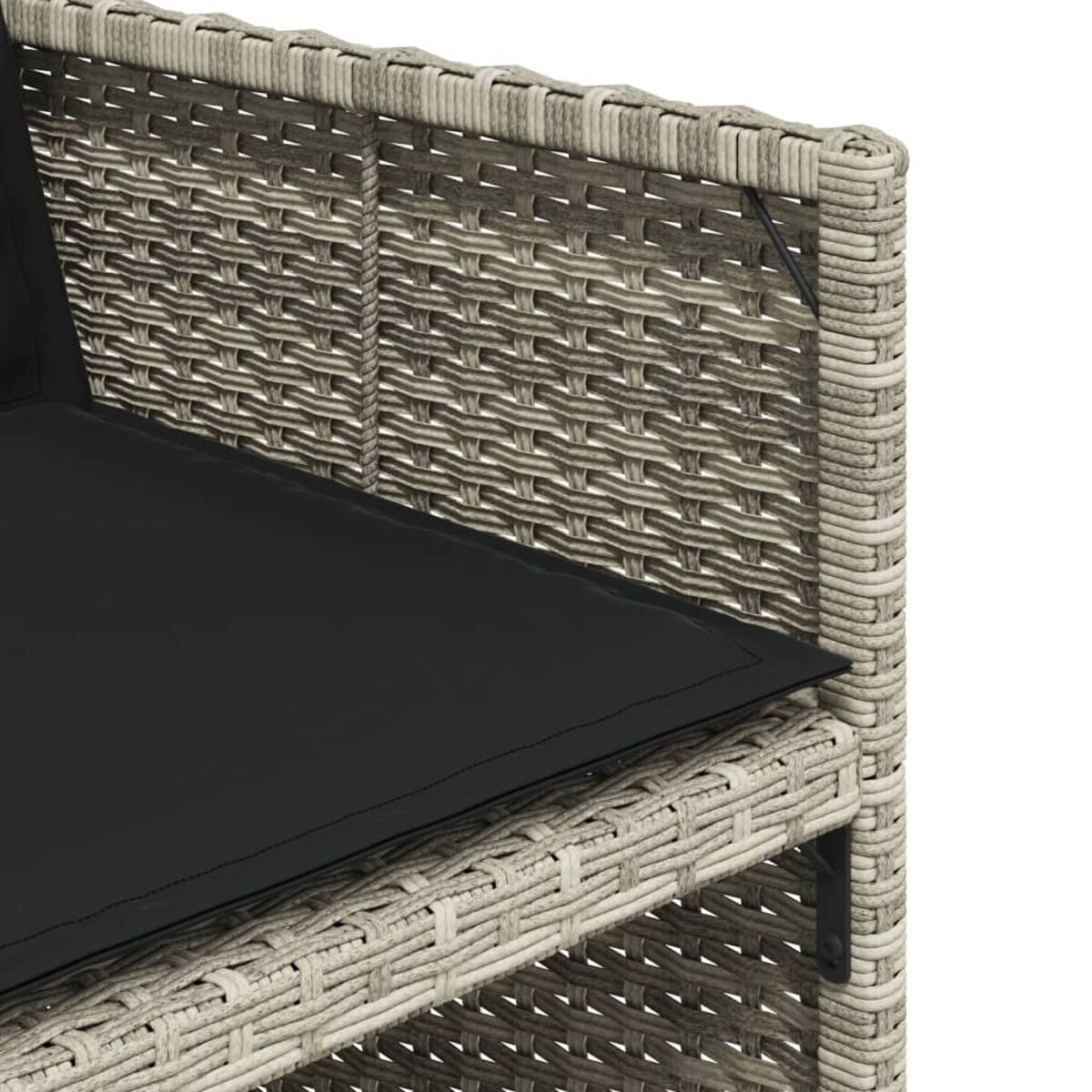 Nahaufnahme der Rattan-Sofaecke mit einem schwarzen Kissen.