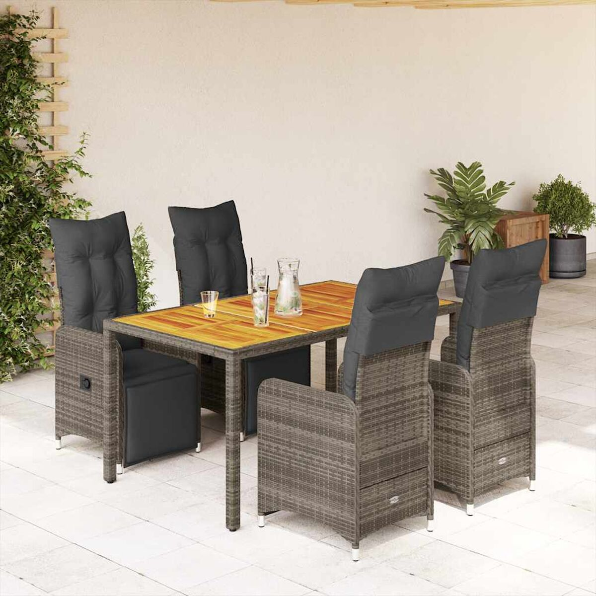 Set da pranzo in vimini da esterno con cuscini grigi. Il tavolo ha il piano in legno. Su un patio.