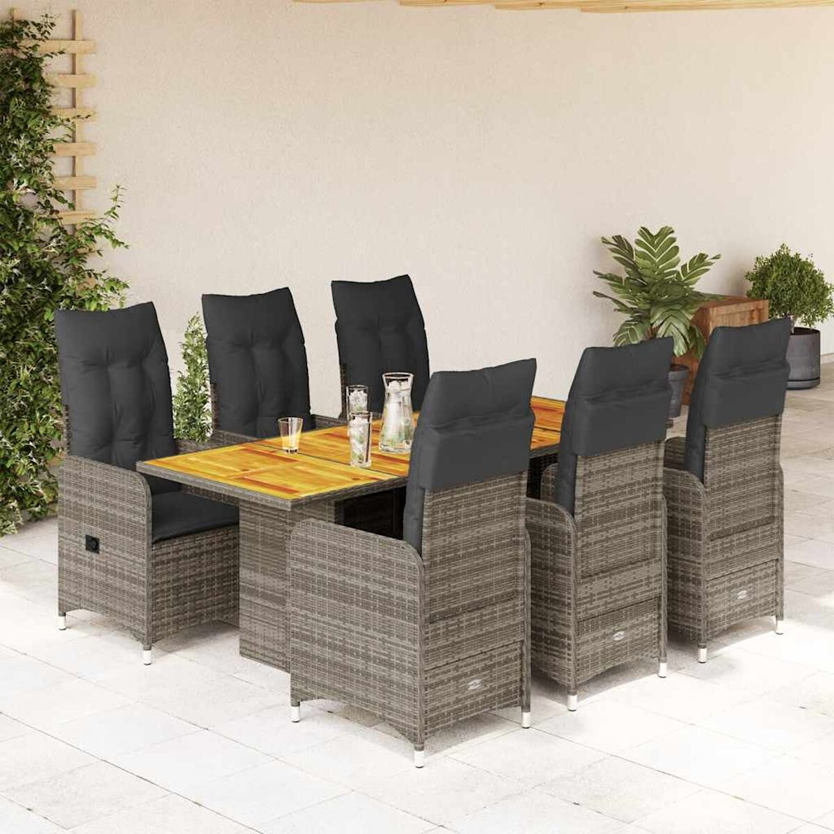 Essgruppe im Freien auf einer Terrasse. Korbstühle, Holztisch mit Glasplatte. Graue Kissen.