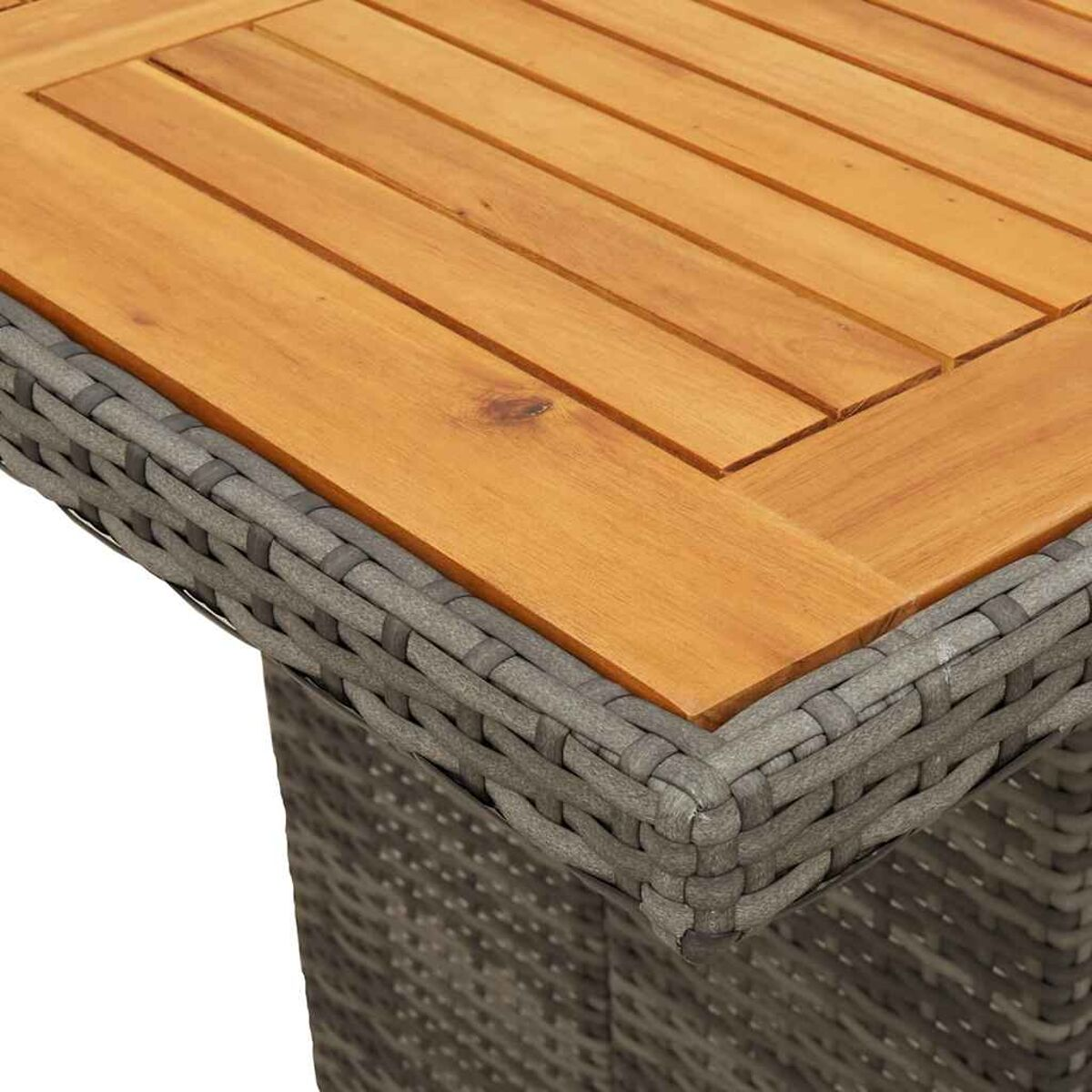 Nahaufnahme eines Tisches. Der Tisch hat eine Holzplatte und einen grauen Rattanfuß. Das Holz hat eine natürliche Farbe.