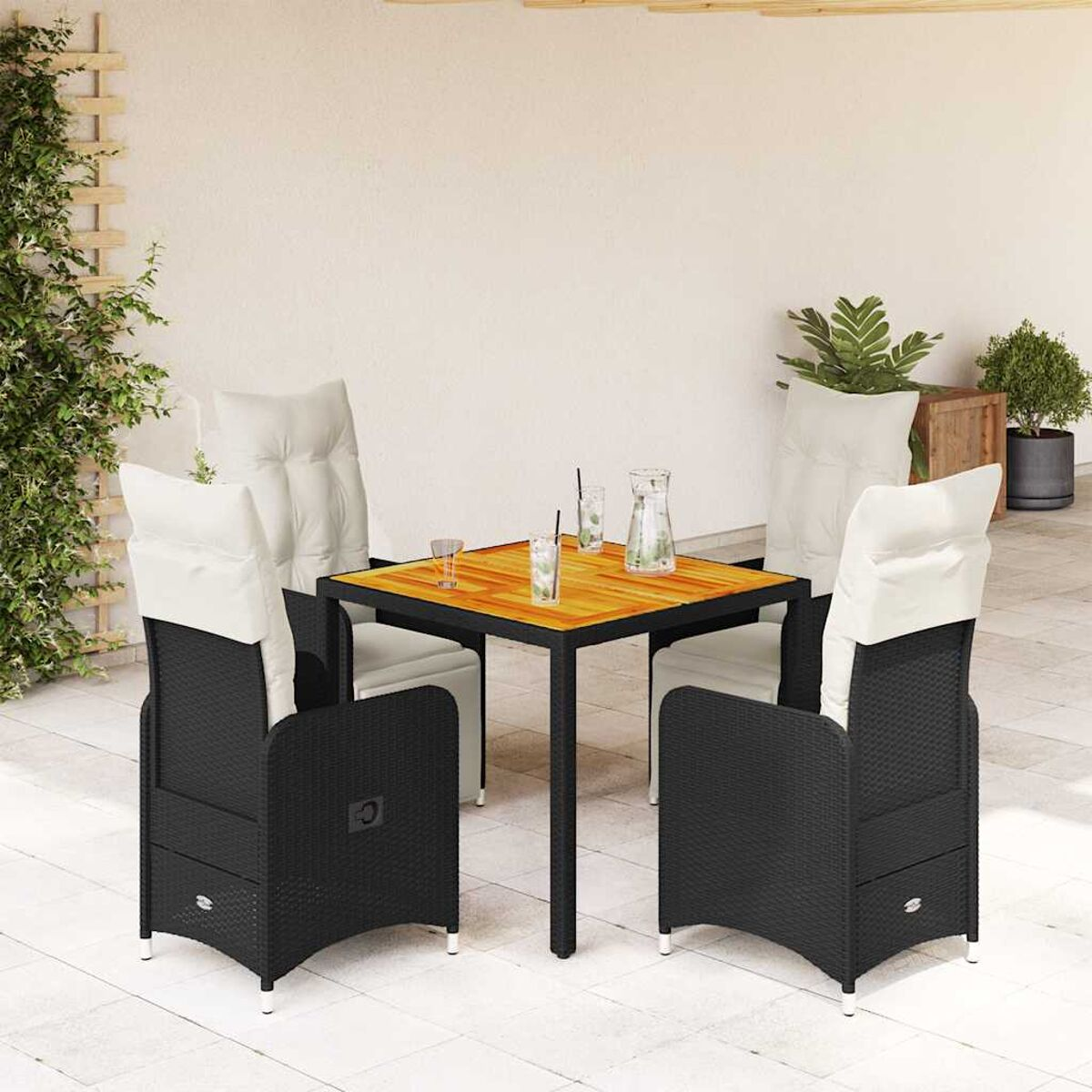 Set da pranzo all'aperto: tavolo quadrato con quattro sedie. Rattan nero, piano in legno, cuscini color crema. Bevande sul tavolo.