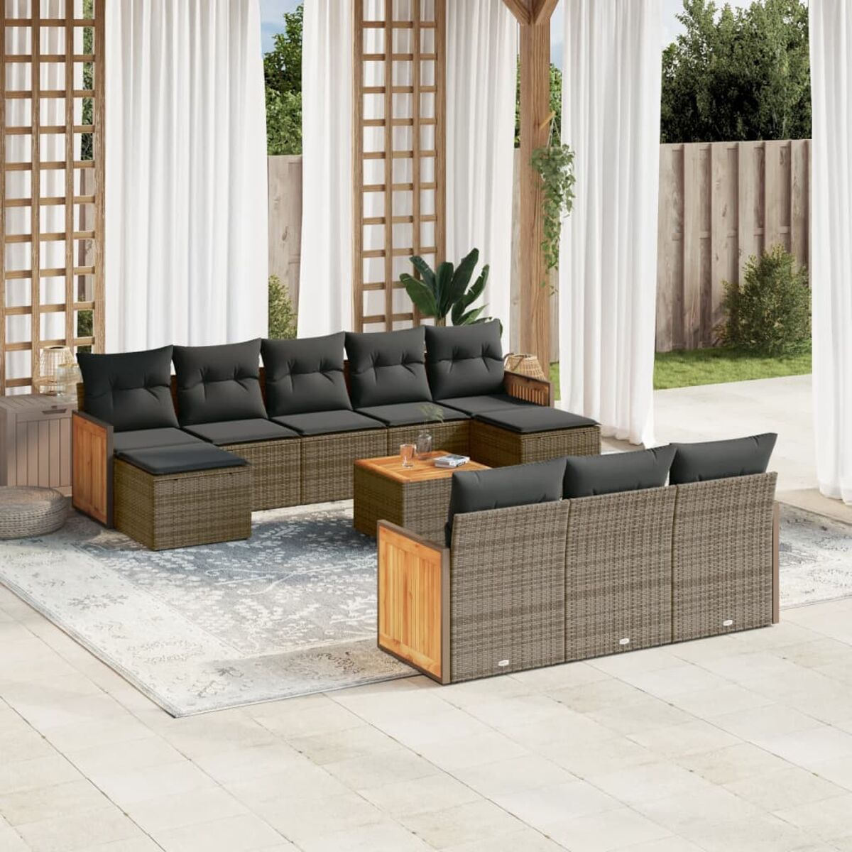 Outdoor-Korbsessel-Set mit grauen Kissen. Enthält einen Couchtisch und weiße Vorhänge im Hintergrund.