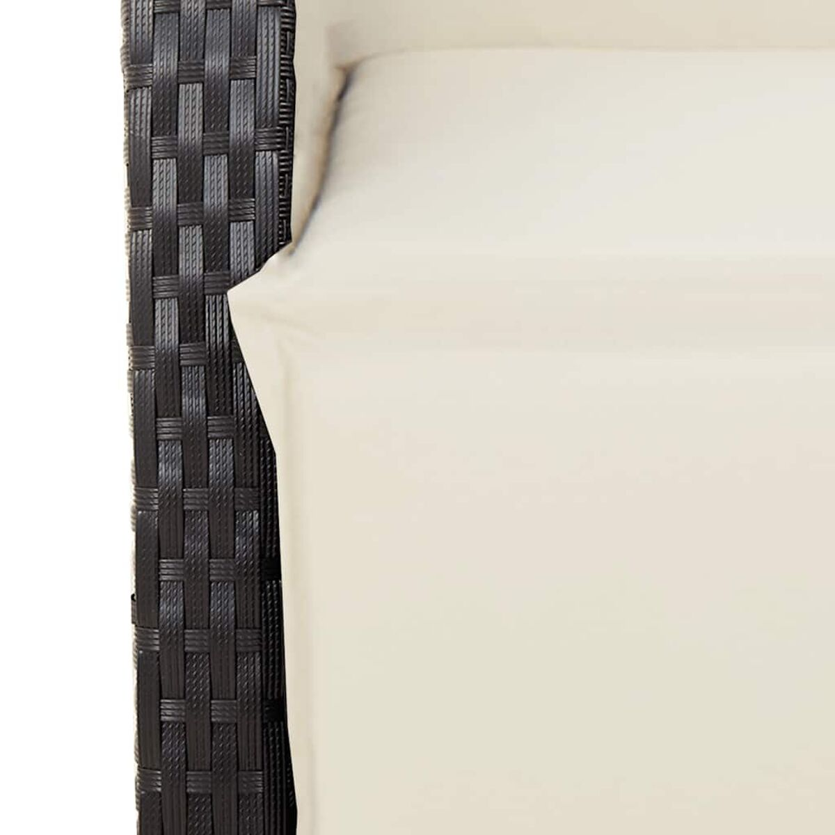 Primo piano di sedia in vimini nera con cuscino crema.