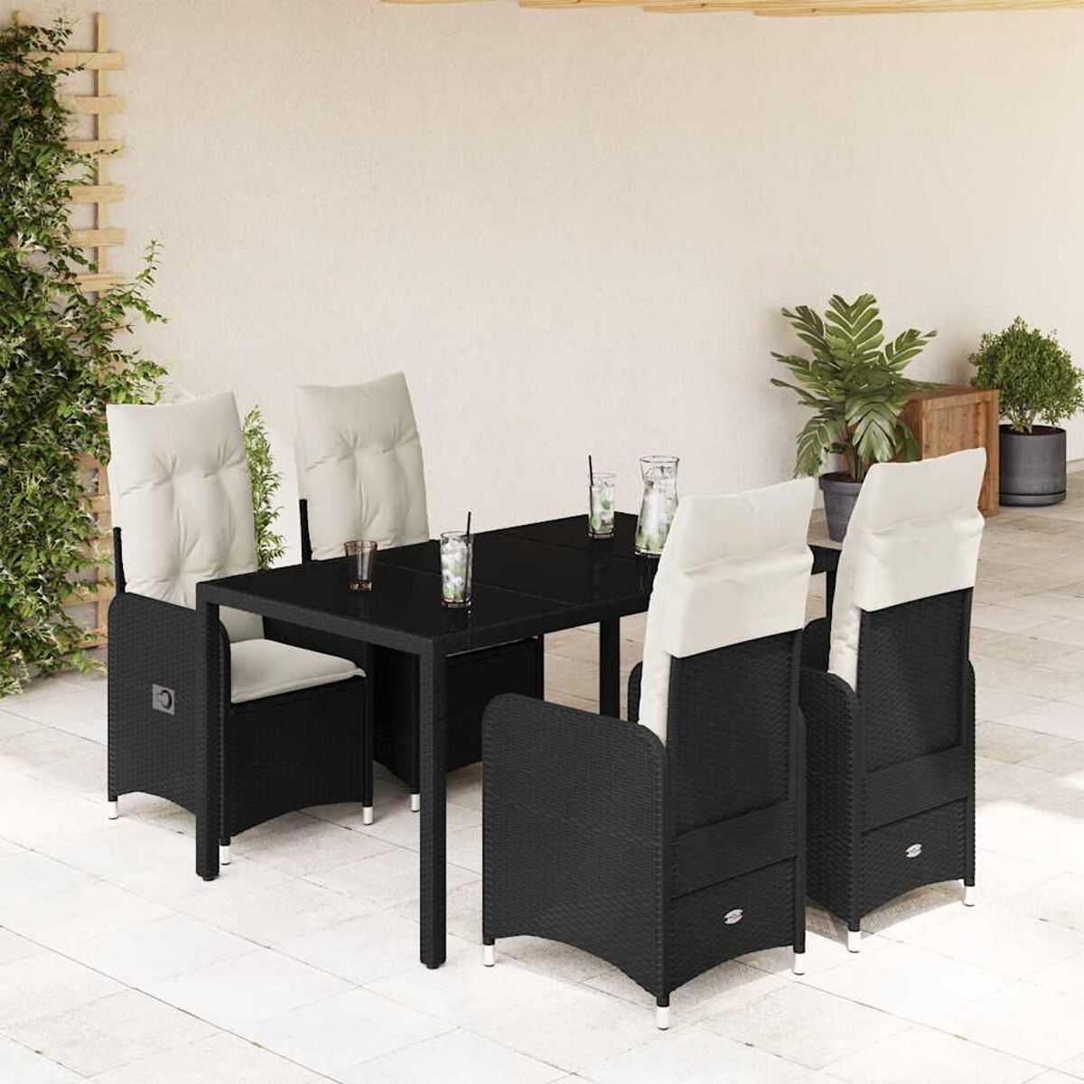 Tavolo in vimini nero con 4 sedie, bicchieri e piante. Ambientazione patio.