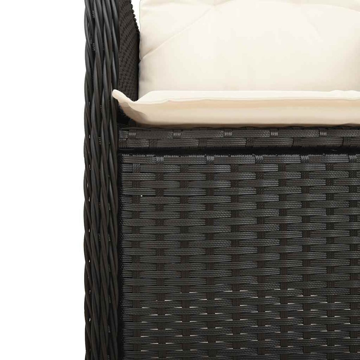 Primo piano di una sedia da esterno in rattan nero intrecciato con un cuscino bianco.
