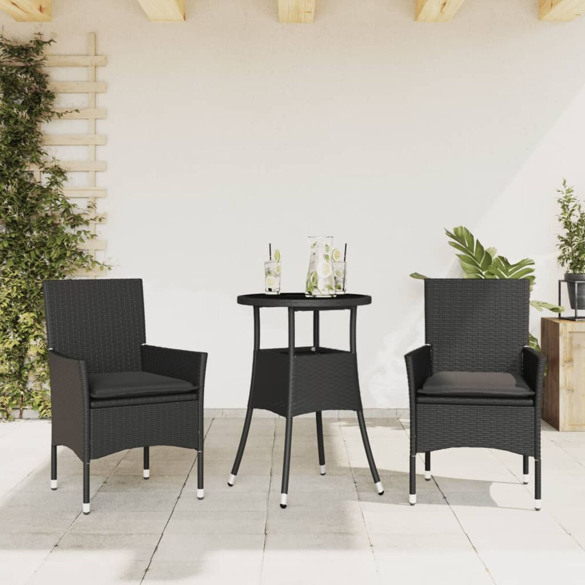 Schwarzes Sitzensemble im Freien mit Tisch und zwei Stühlen auf einer Terrasse.