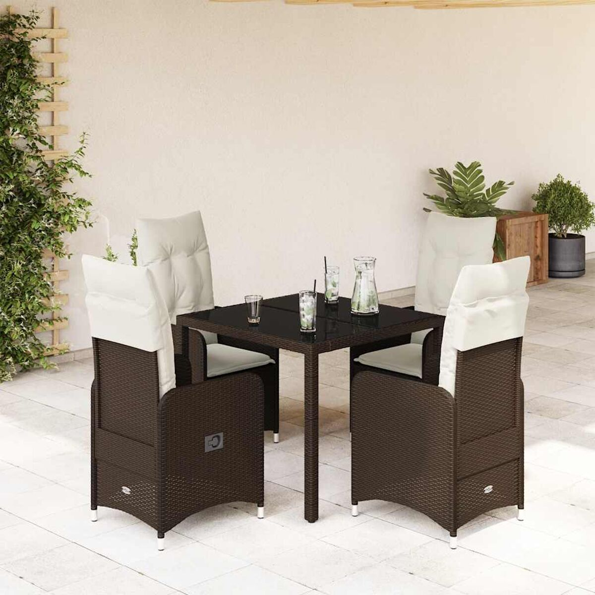 Set da pranzo esterno in vimini marrone con cuscini bianchi, tavolo e sedie.