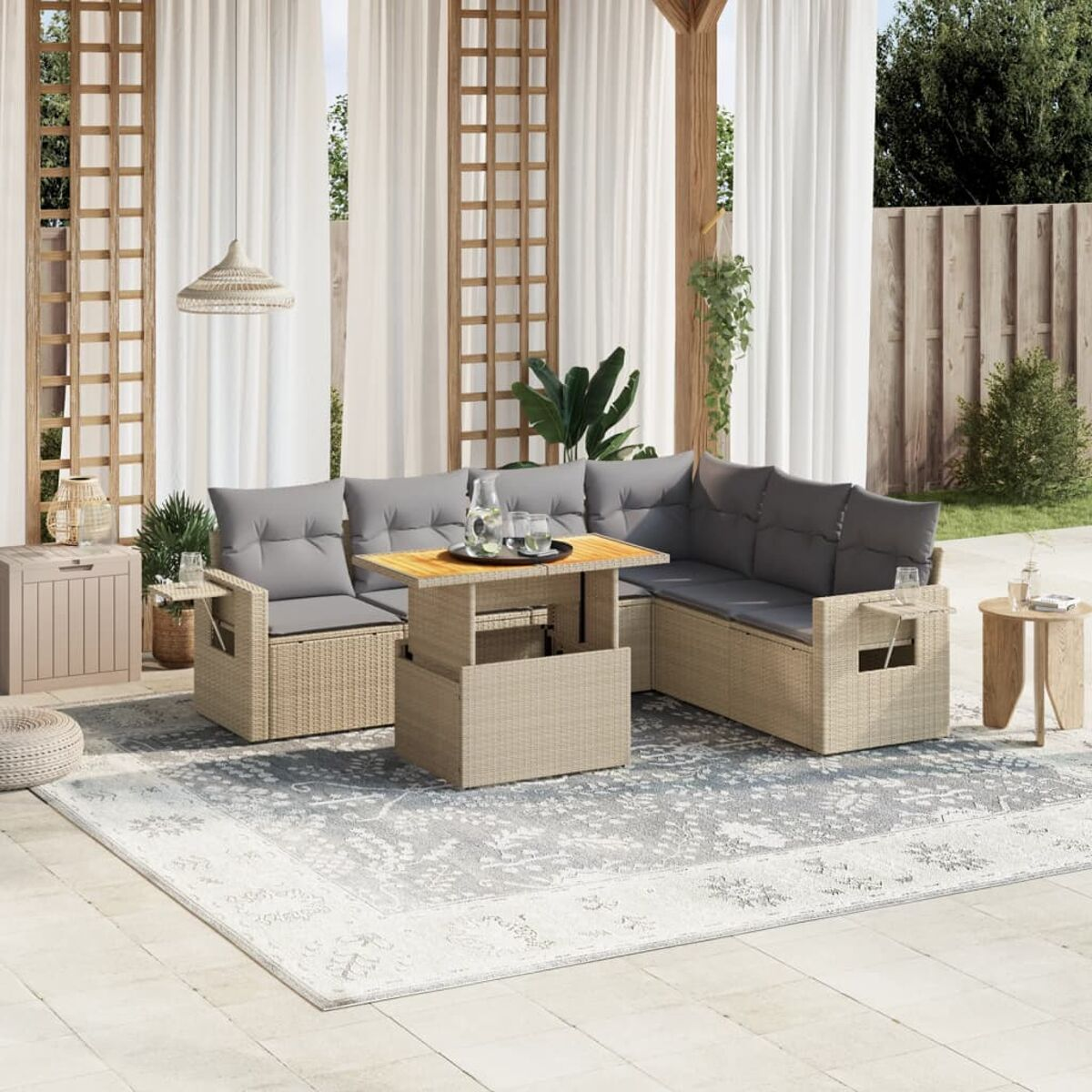 Outdoor-Sitzbereich mit einem Ecksofa aus beigem Korbgeflecht, einem Holztisch und grauen Kissen auf einem Teppich.