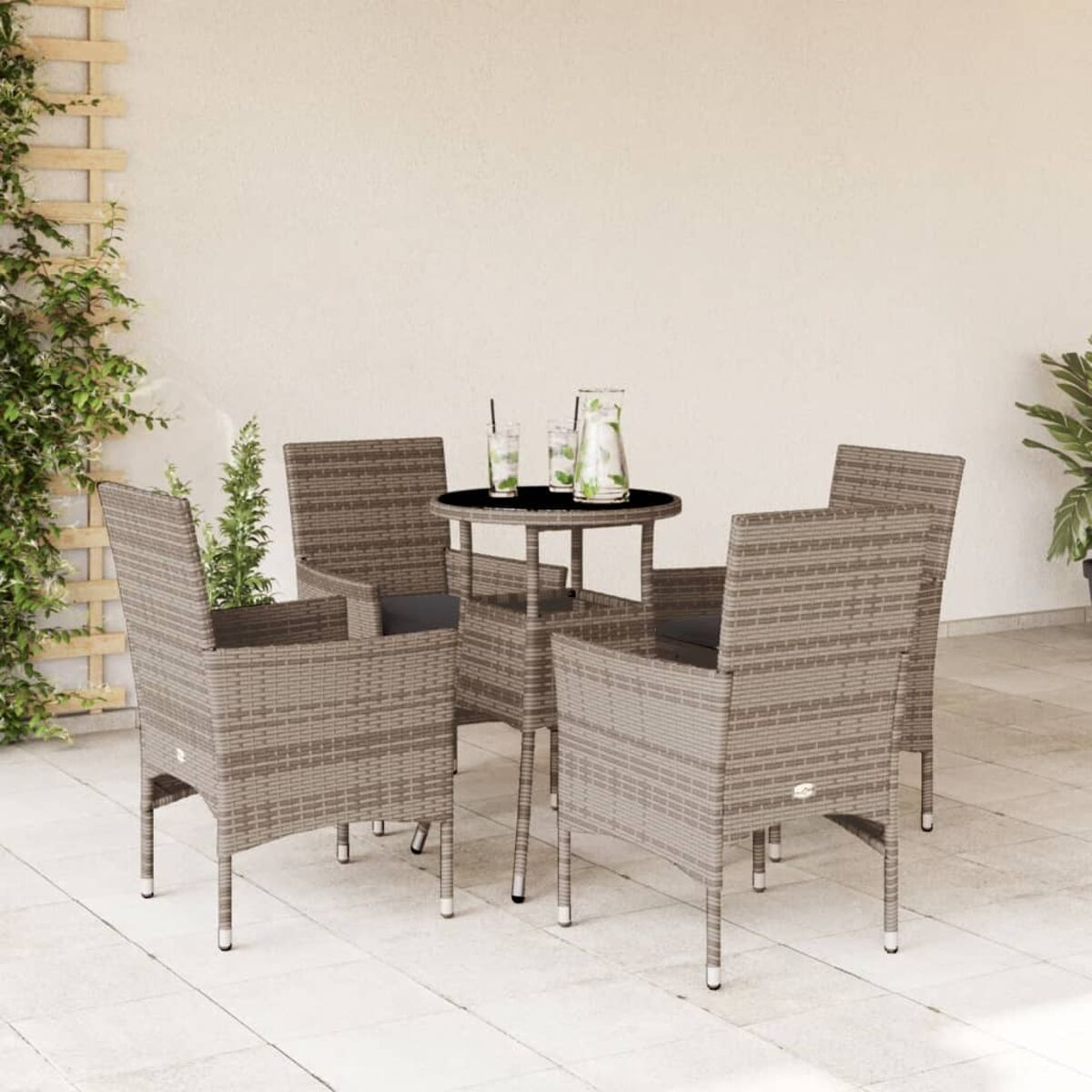 Outdoor-Terrassenmöbel mit grauen Korbmöbeln und einem kleinen Tisch mit Getränken.