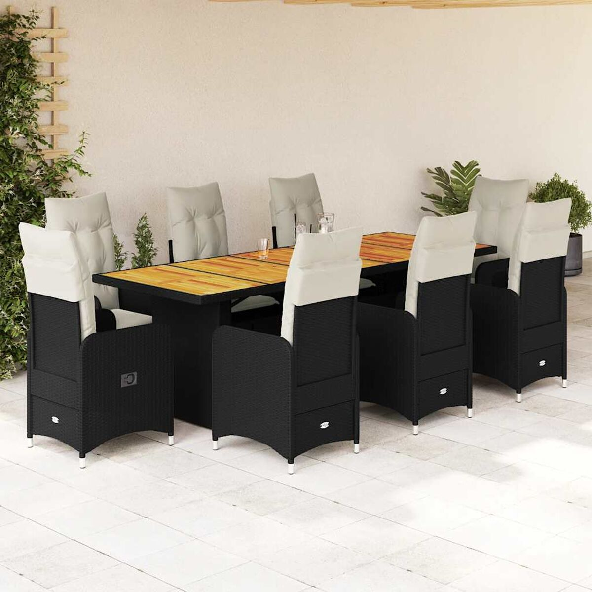 Essgruppe im Freien: schwarze Korbstühle, helle Kissen, Holztisch. Szene ist im Freien.