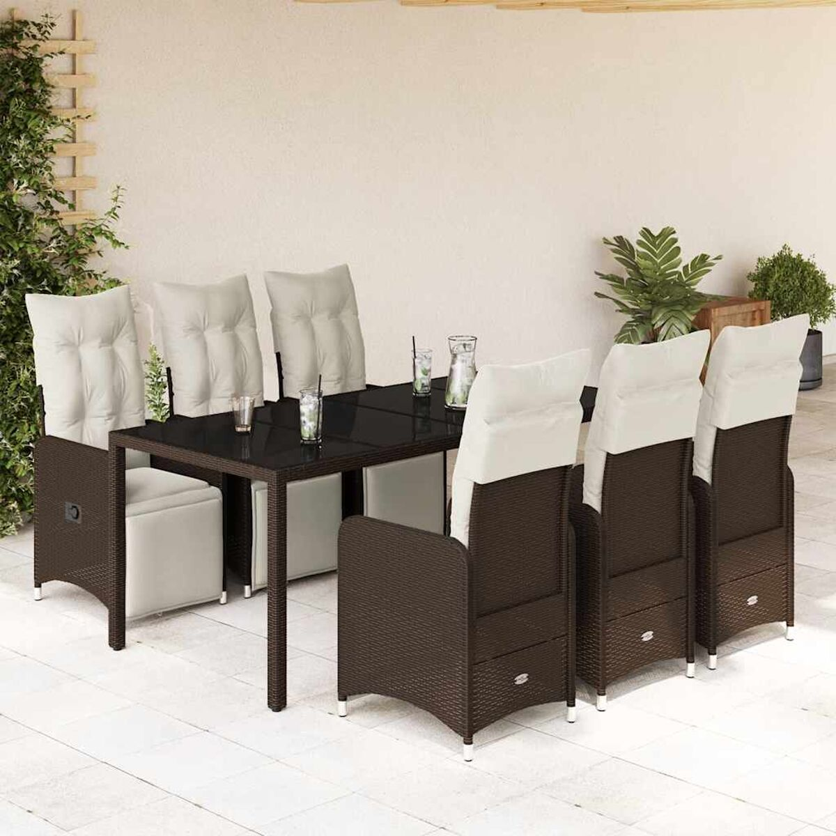 Set da pranzo all'aperto: tavolo e sedie scuri, e accessori su un patio. Piante e casa sullo sfondo.