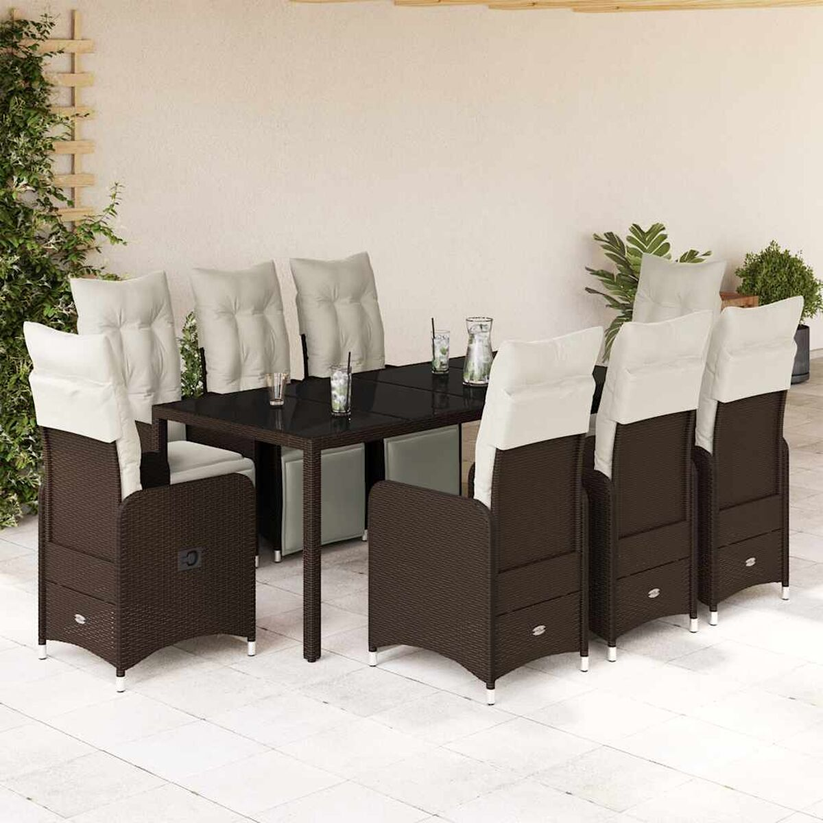 Un set da pranzo per esterni con aspetto vimini marrone scuro. Tavolo con bicchieri e sedie con cuscini bianchi.
