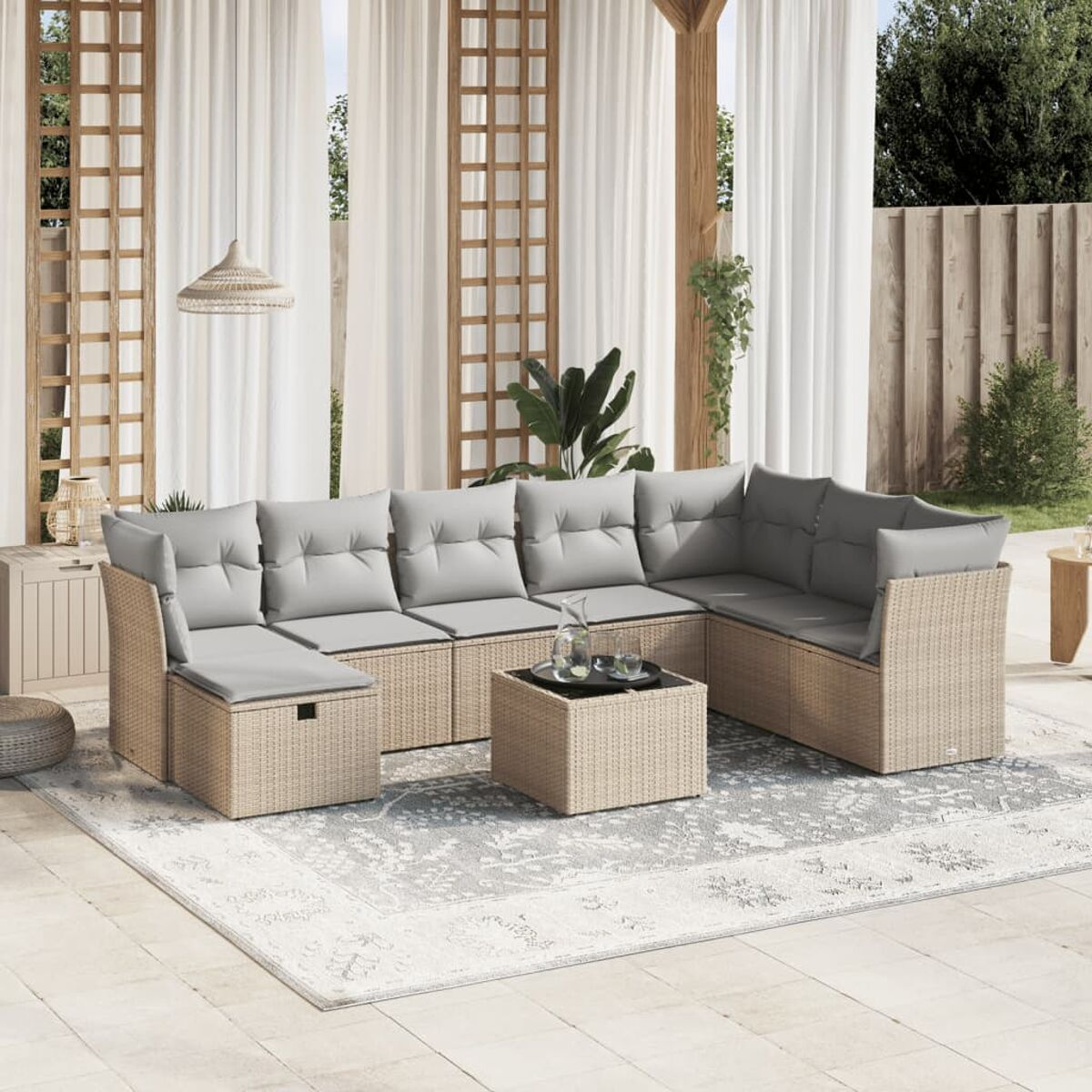 Outdoor-Korbssofa-Set mit grauen Kissen. Enthält einen Couchtisch und einen hellen Teppich.
