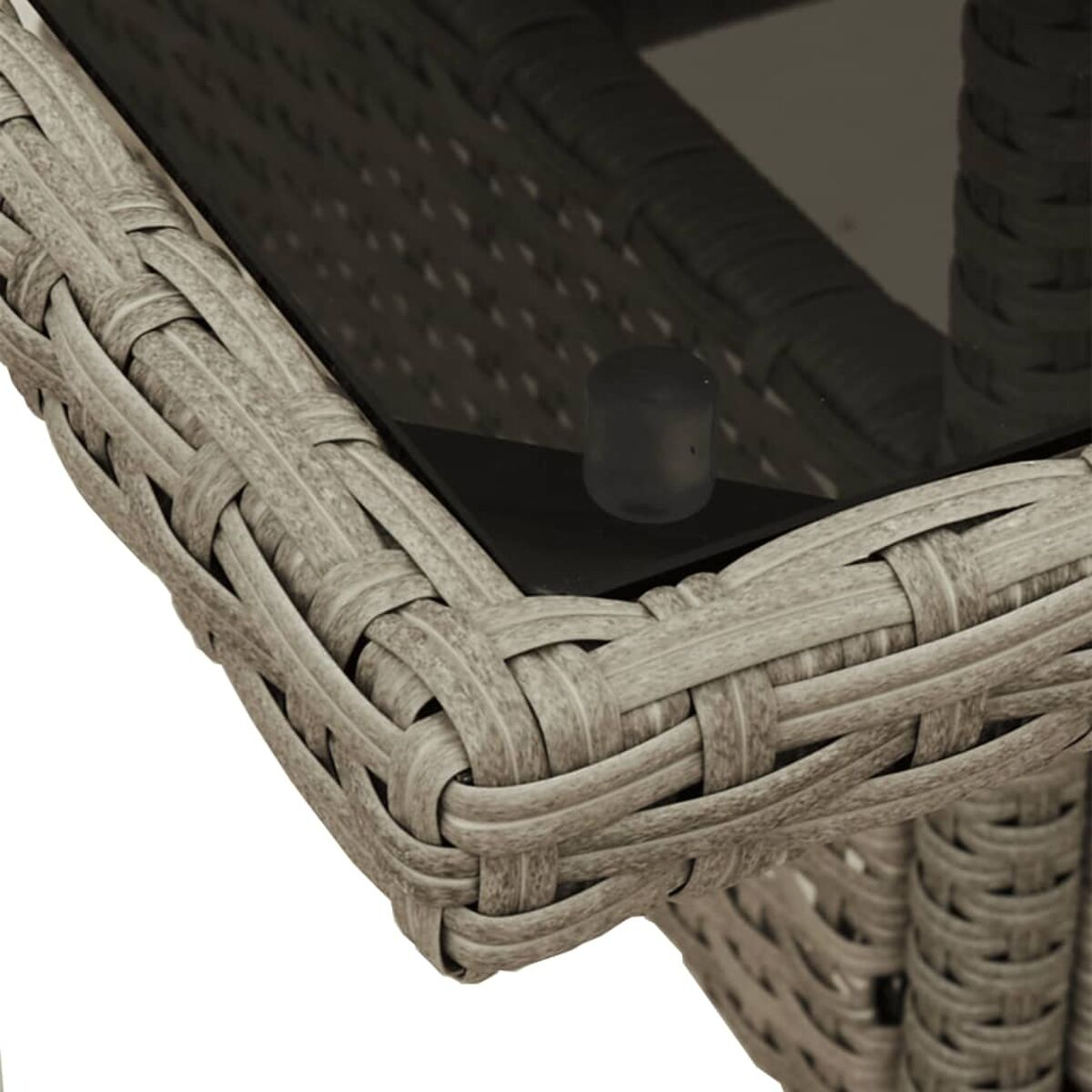 Nahaufnahme des gewebten Materials an einer Tischkante. Graues Geflecht mit dunkler Oberfläche, zeigt ein kleines Bein.