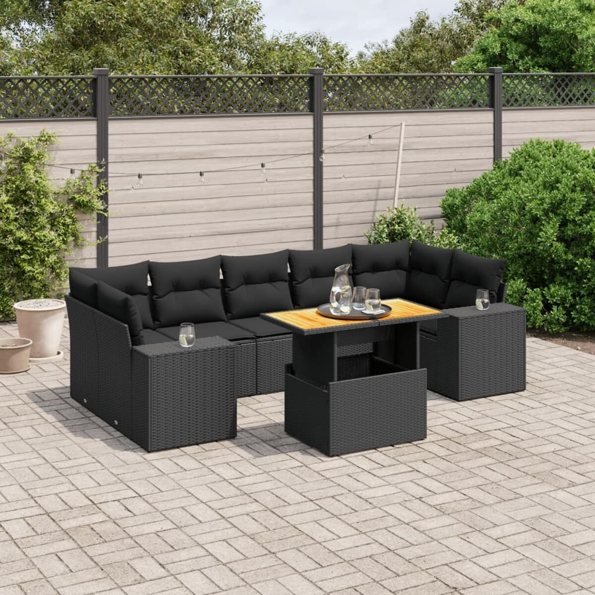 Outdoor-Möbelset aus schwarzem Korbgeflecht. Ein Tisch und Sitzgelegenheiten für mehrere Personen.